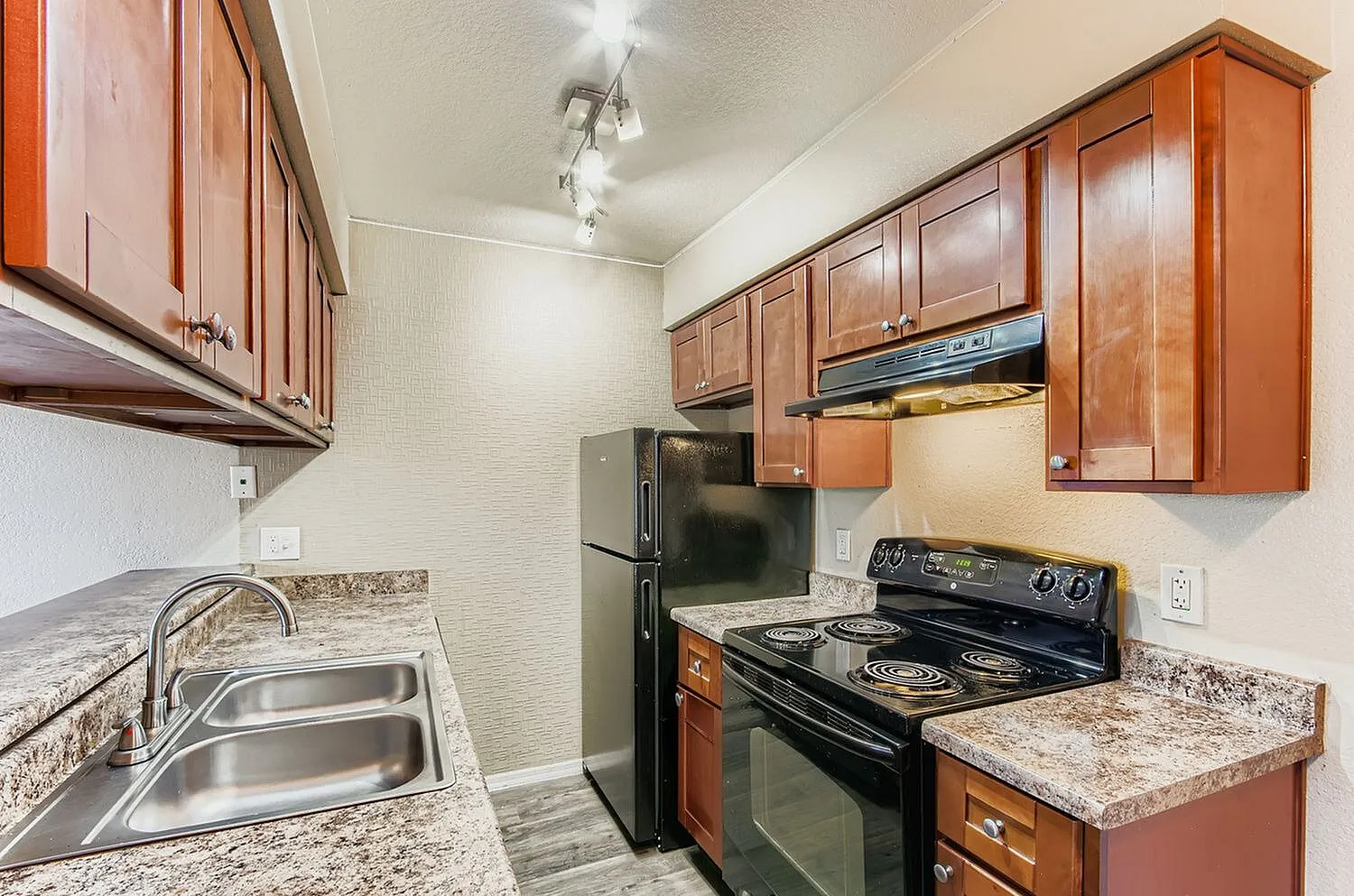Kitchen, wood cabinetry, granite countertops, black range and refrigerator