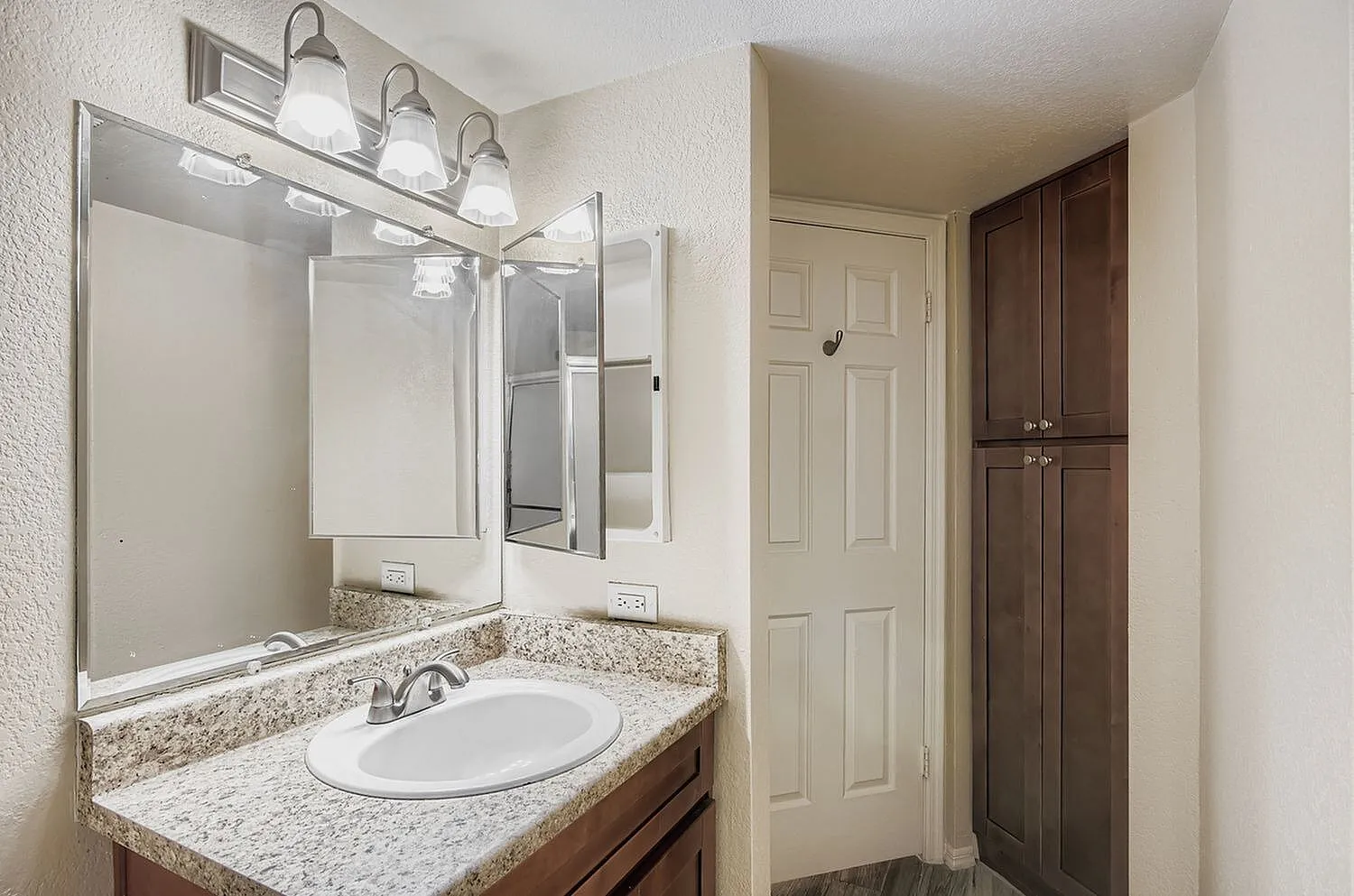 Bathroom, granite countertops, round sink, dark wood vanity, framed mirror