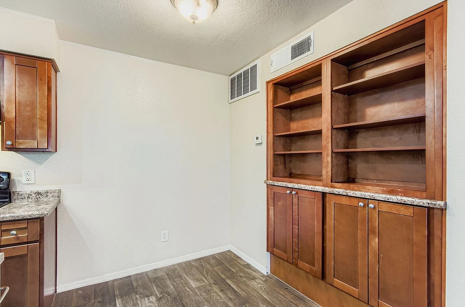 Home office, wood cabinetry with shelving, granite countertop, wood-style plank flooring