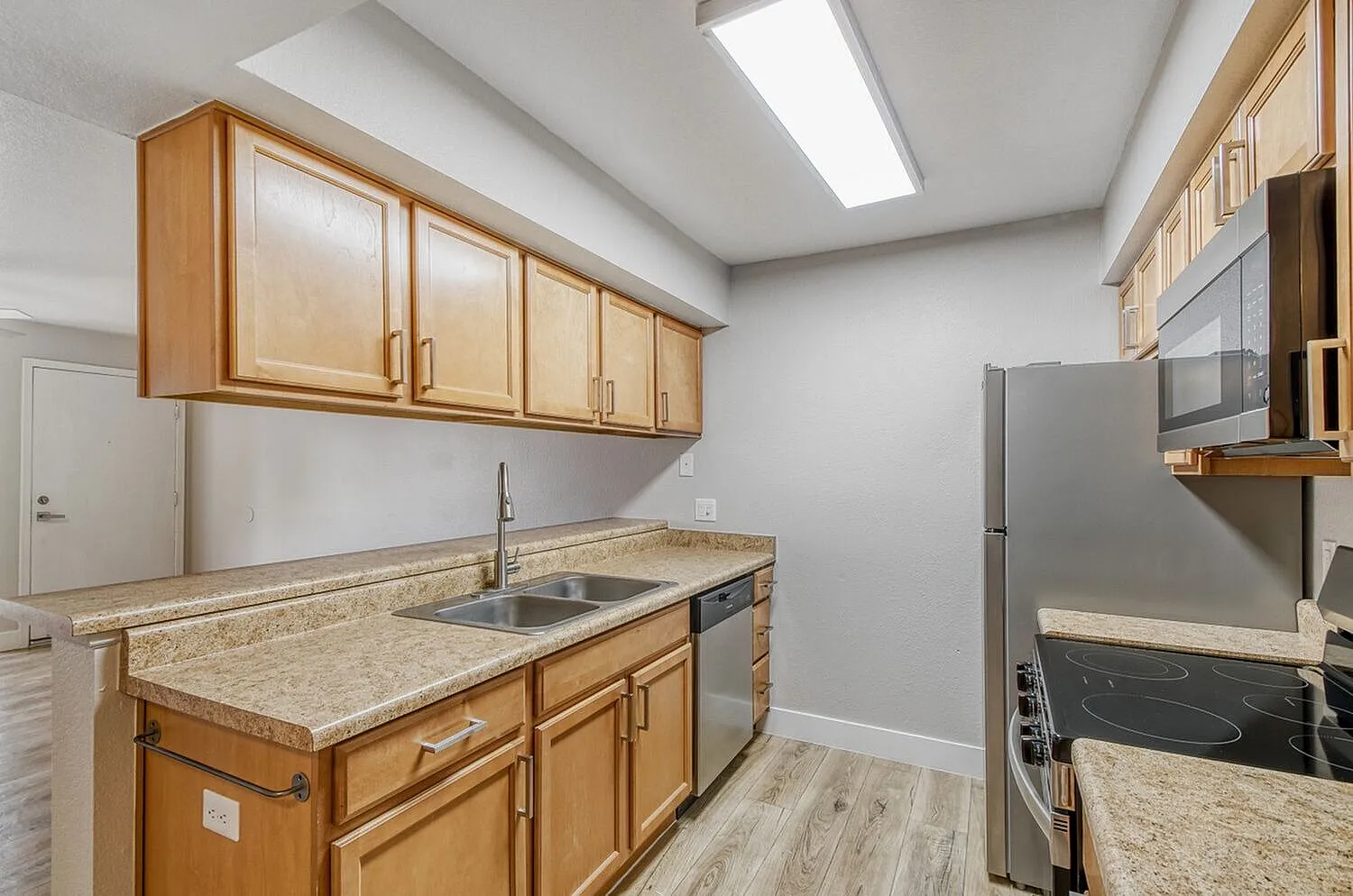 Kitchen, wood cabinetry, granite countertops, stainless appliances, wood-style plank flooring