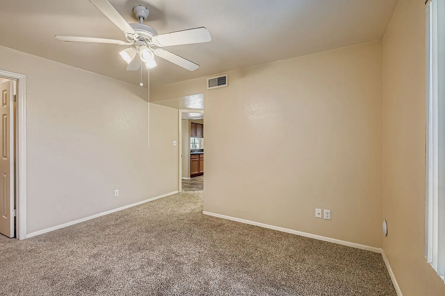Primary bedroom, beige walls, ceiling fan with lights, carpeted flooring, mirrored closet doors