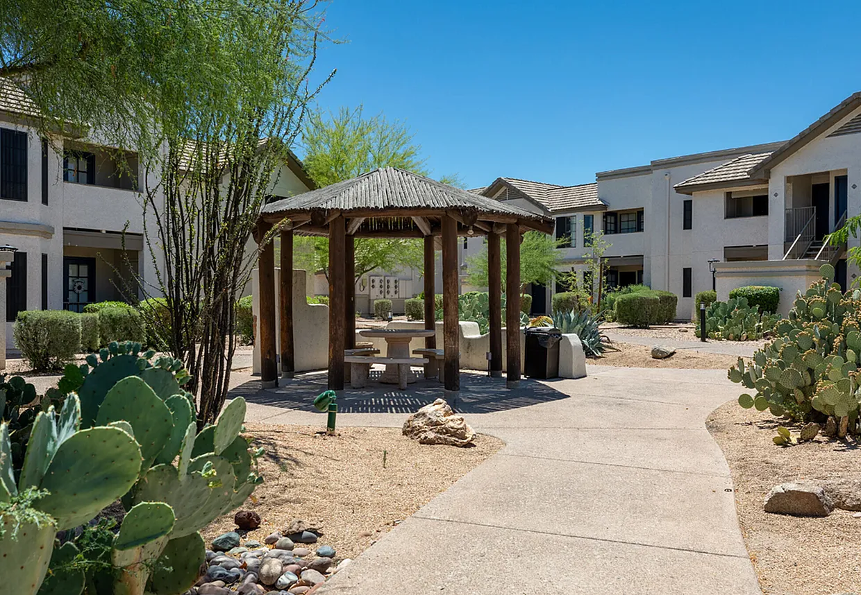 Courtyard with wooden pergola, desert landscaping, patio area, residential buildings