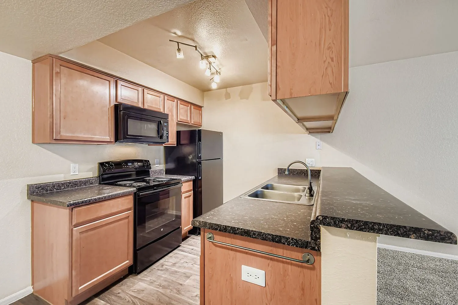 Kitchen, wood cabinetry, granite countertops, black appliances, wood-style plank flooring
