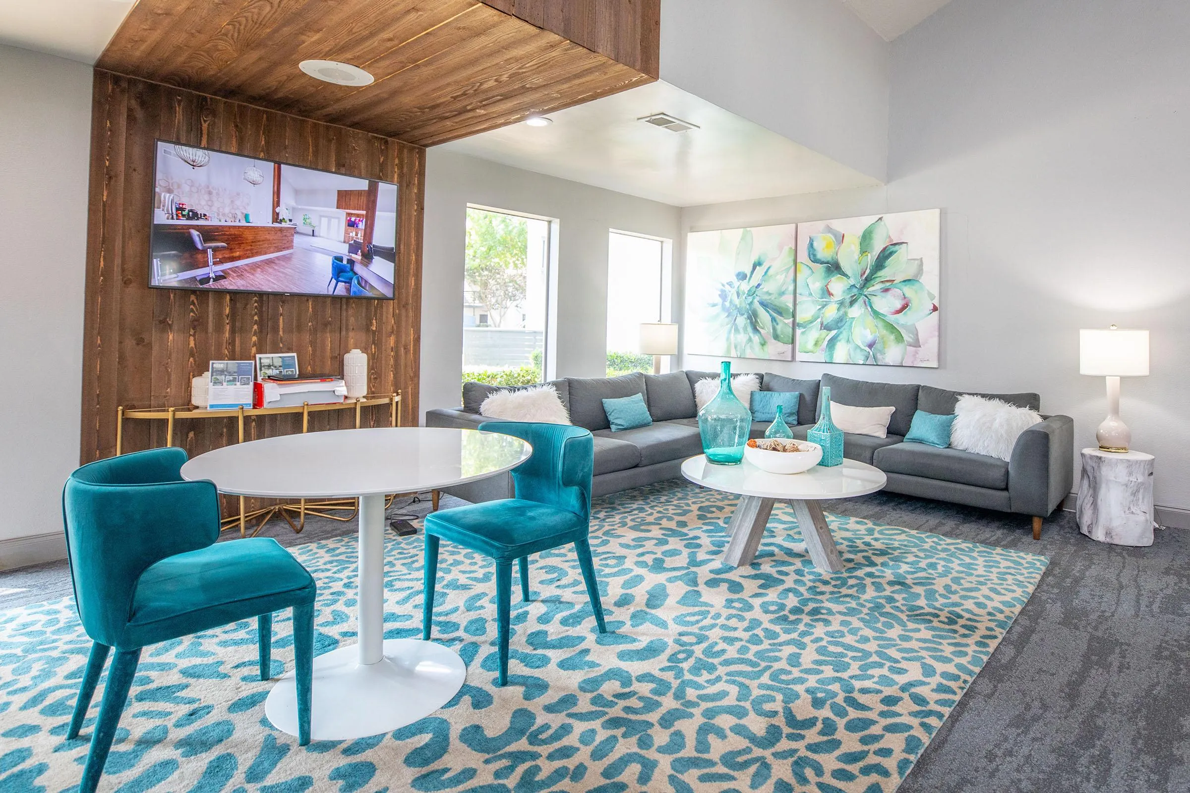 Sectional sofa, mounted TV, leopard-print rug, teal accents