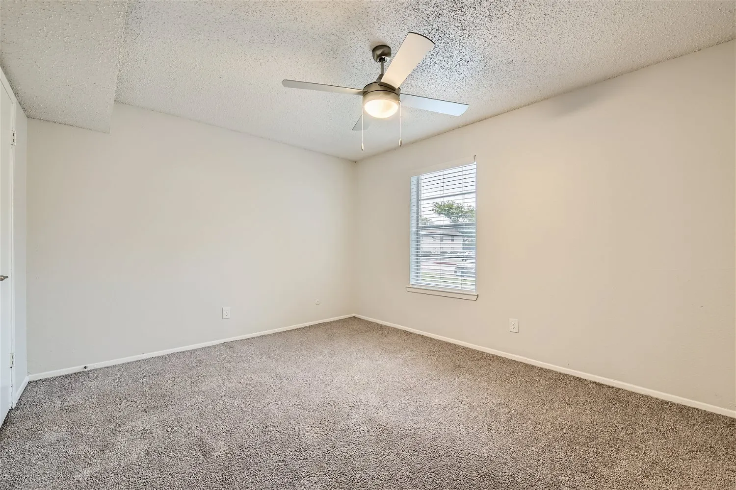 Second bedroom with ceiling fan and large window