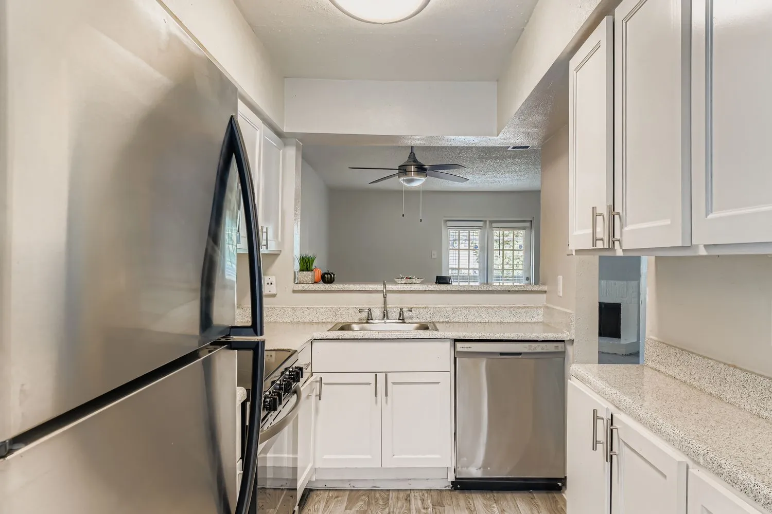 Stainless refrigerator, dishwasher, granite counters, open sightline to living room