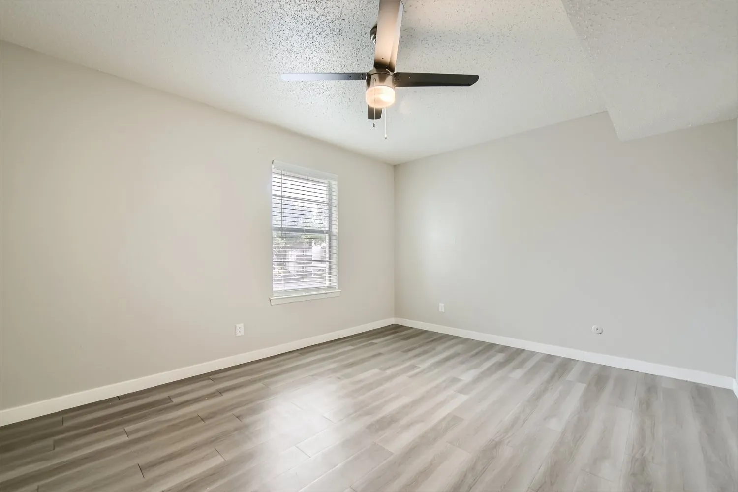 Second bedroom with ceiling fan and large window