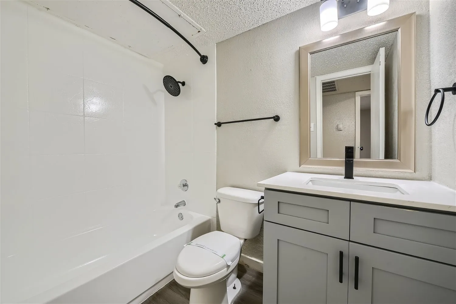 Second bathroom with tub shower combo and gray vanity