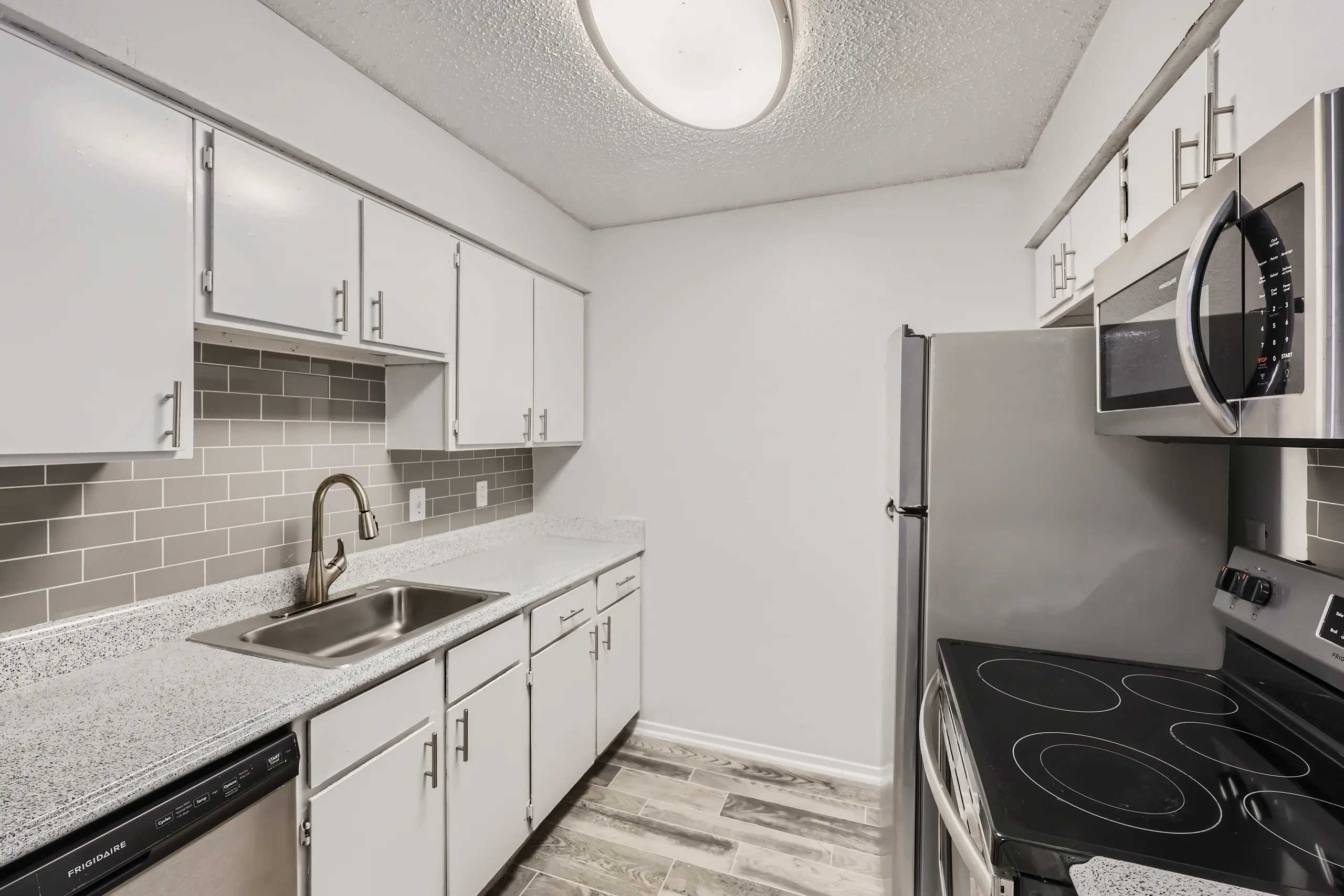 Kitchen with white cabinetry, subway tile backsplash, and stainless appliances