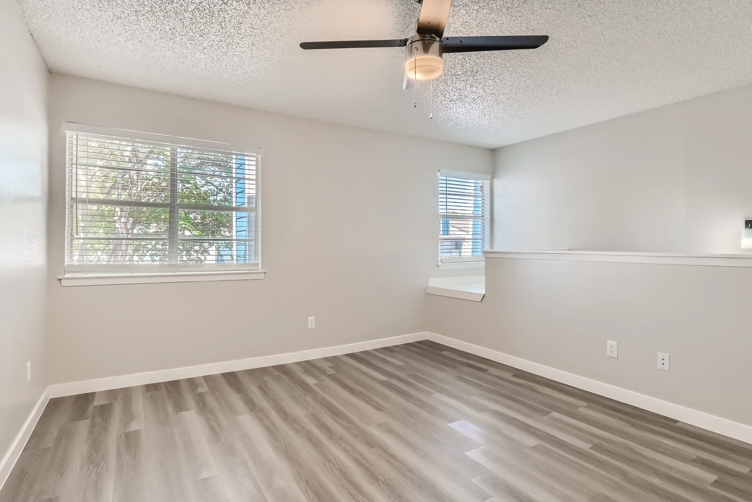 Second floor primary bedroom with ceiling fan and dual windows