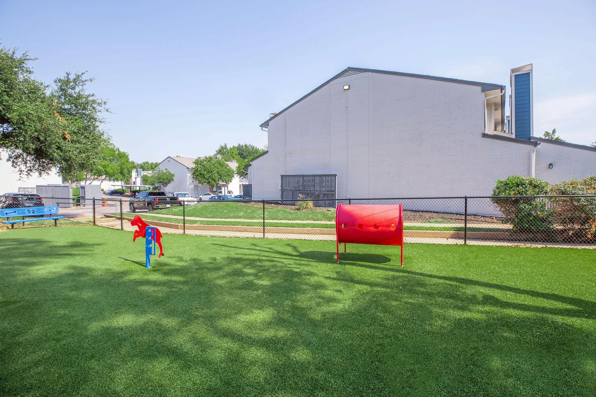 Fenced dog park, turf surface, agility equipment, waste station