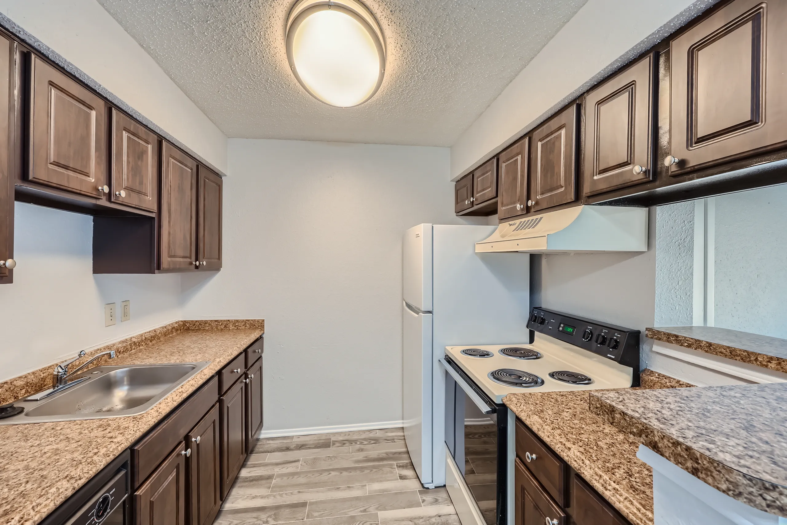 Kitchen with dark wood cabinetry and granite-style countertops