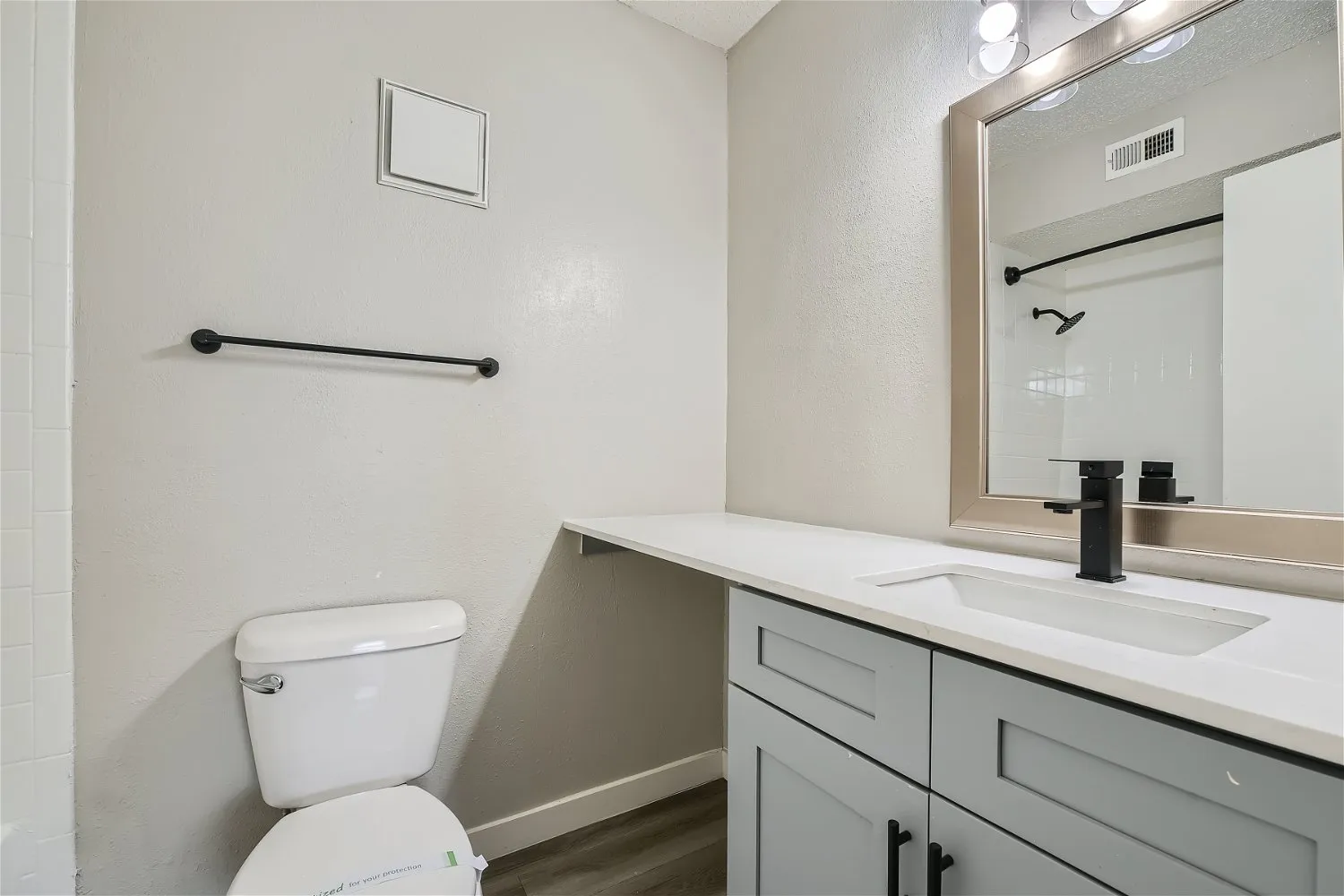 Primary bathroom with gray vanity and matte black fixtures