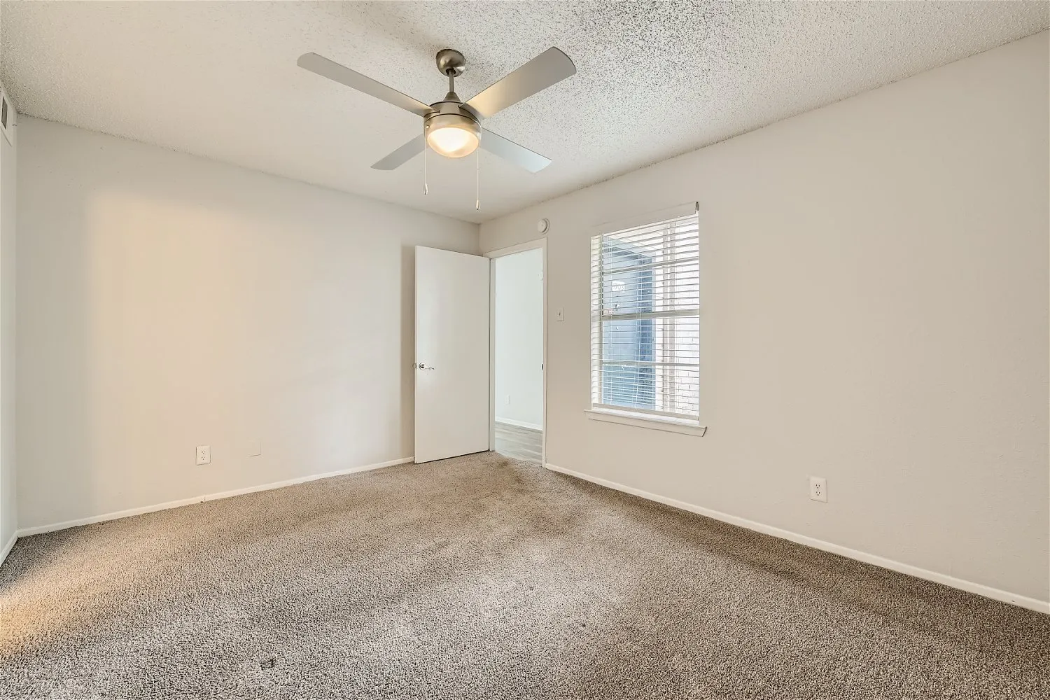 Primary bedroom with ceiling fan and large window