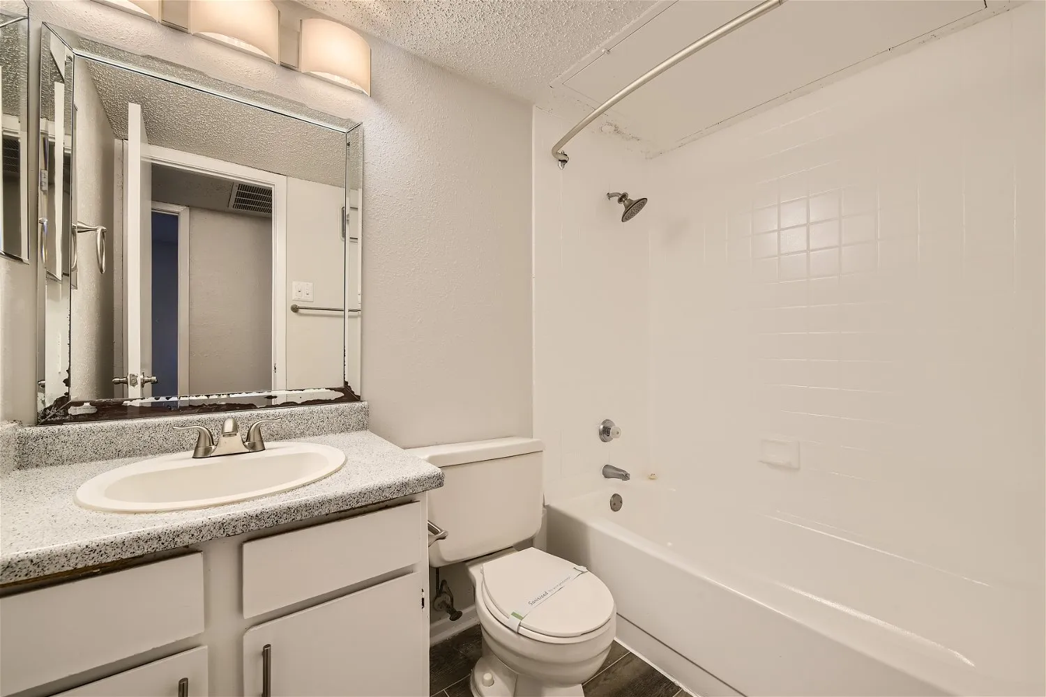 Second bathroom with tub shower combo and vanity mirror