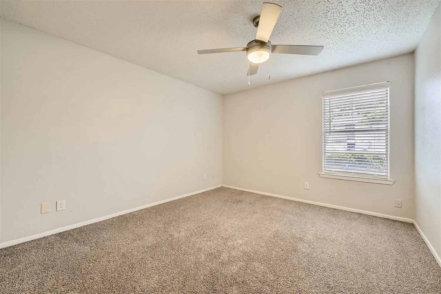 Second bedroom with ceiling fan and large window