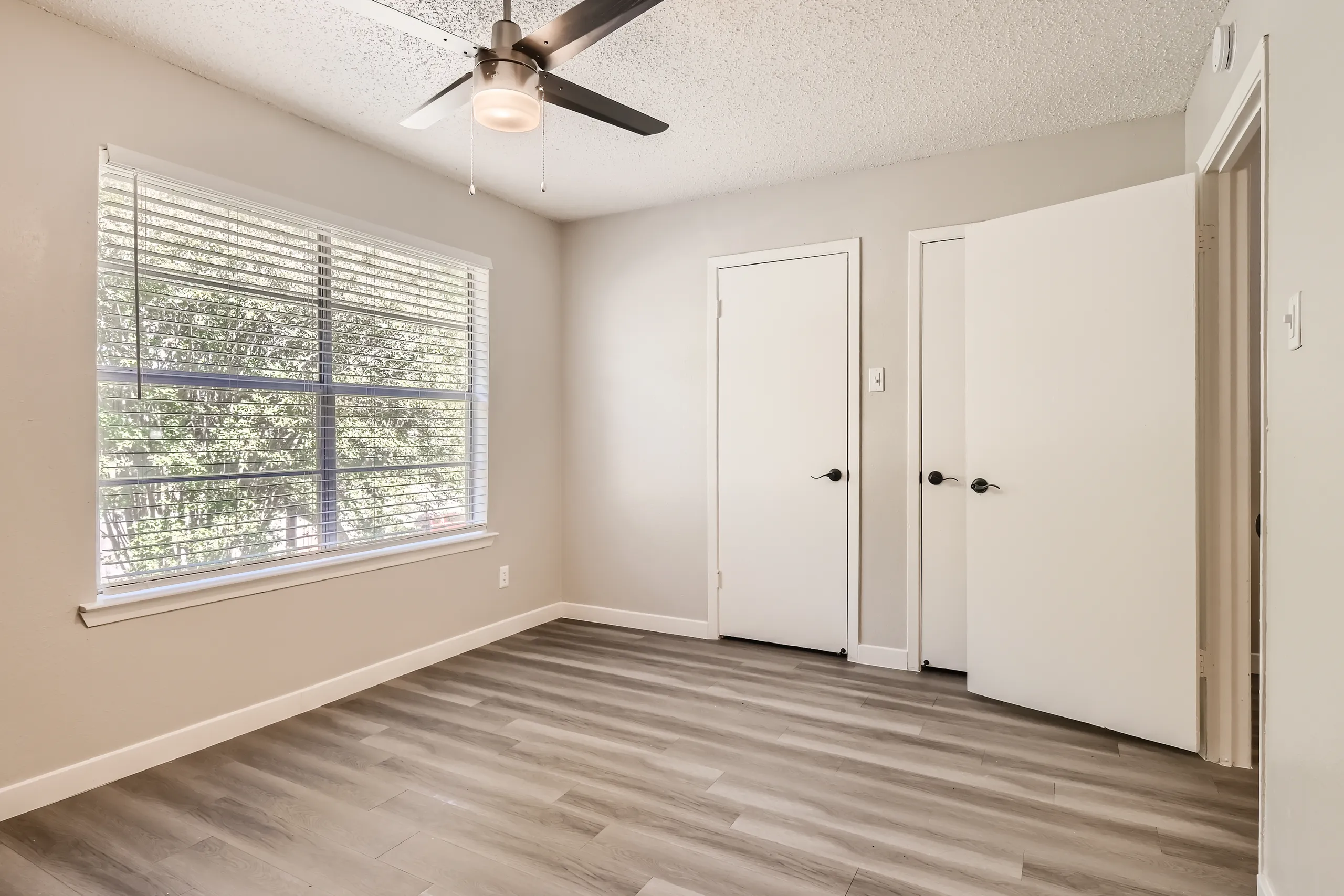 Second bedroom with ceiling fan and closet access