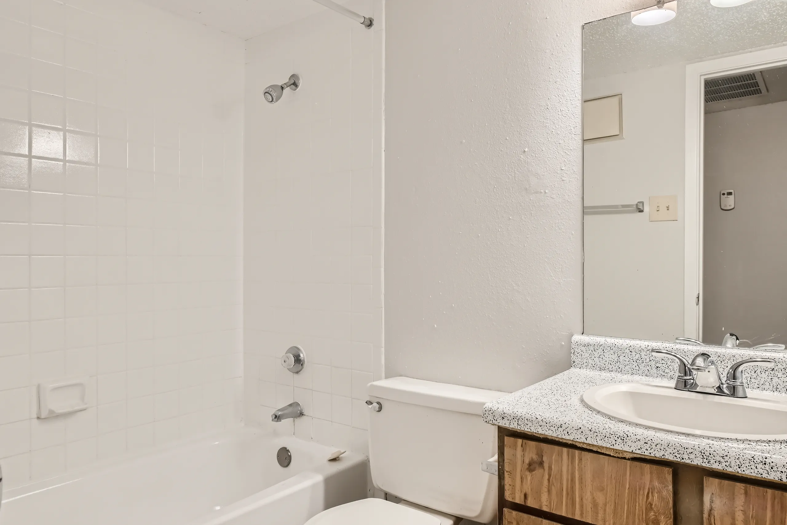 Second bathroom with tub shower combo and vanity mirror