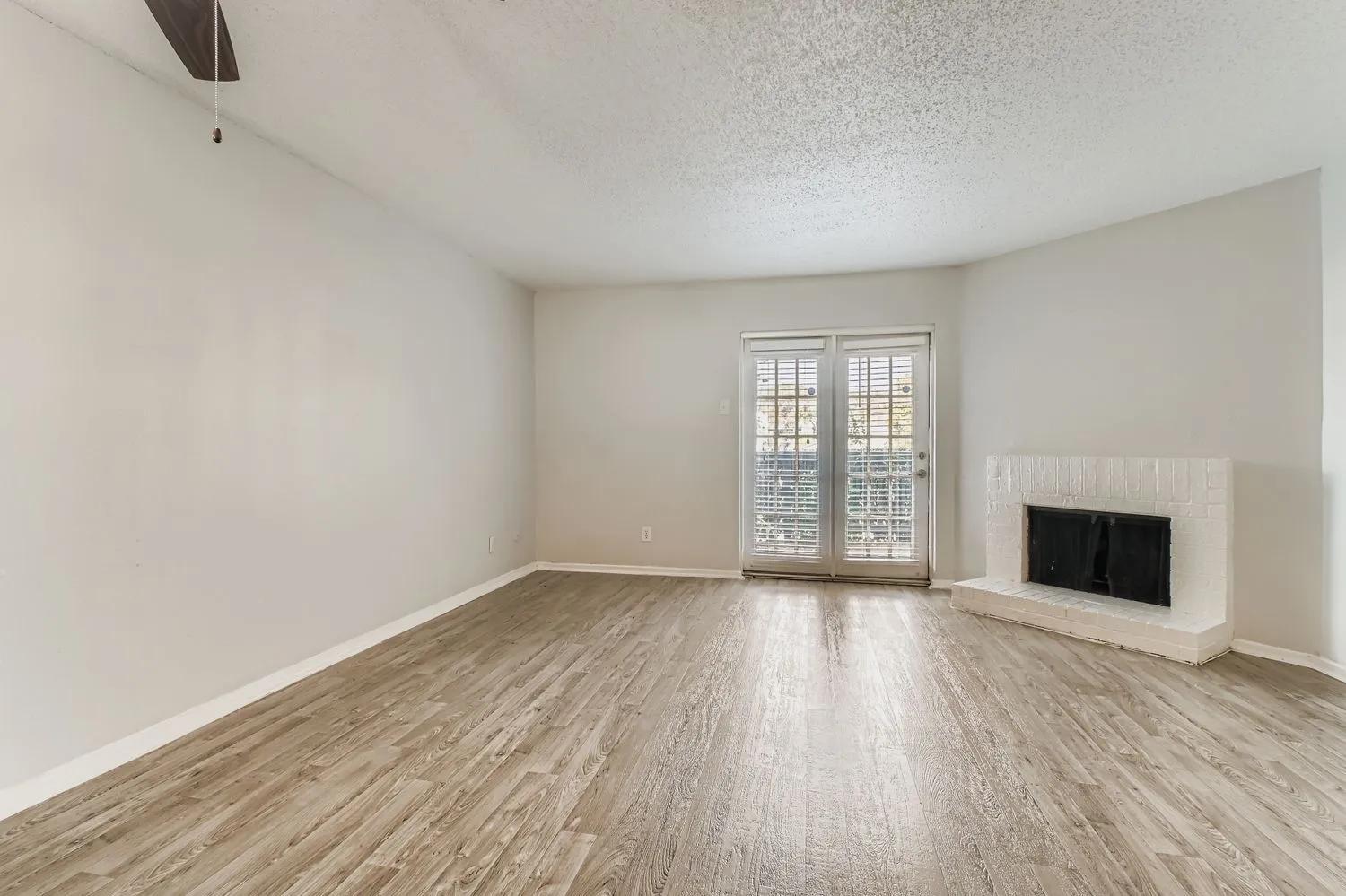 B3 Silver living room, wood-style flooring, ceiling fan, brick fireplace, sliding glass door