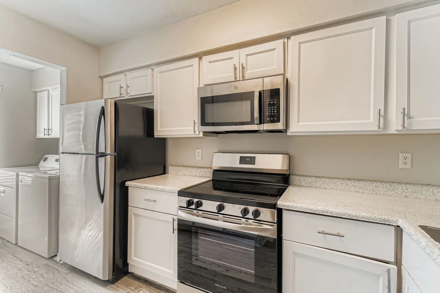 White cabinetry, stainless appliances, granite countertops, in-unit washer/dryer