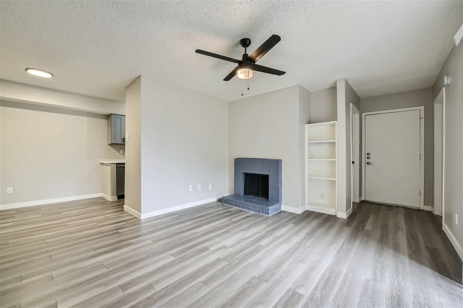 B1 Platinum floor plan living room with painted brick fireplace and built-in shelving