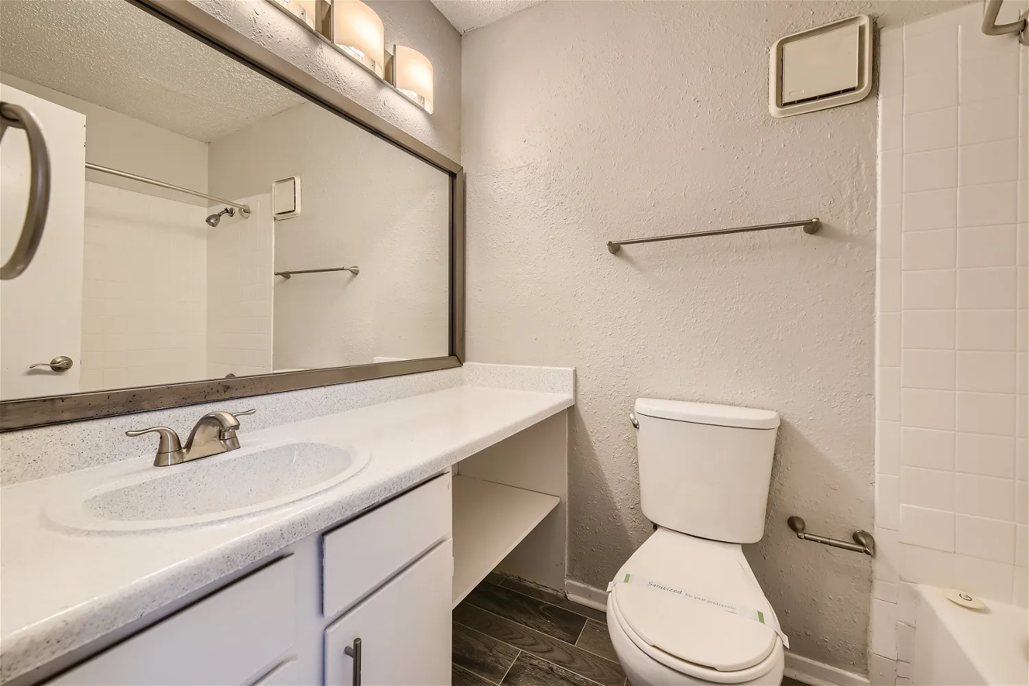 Primary bathroom with speckled vanity and tub shower combo