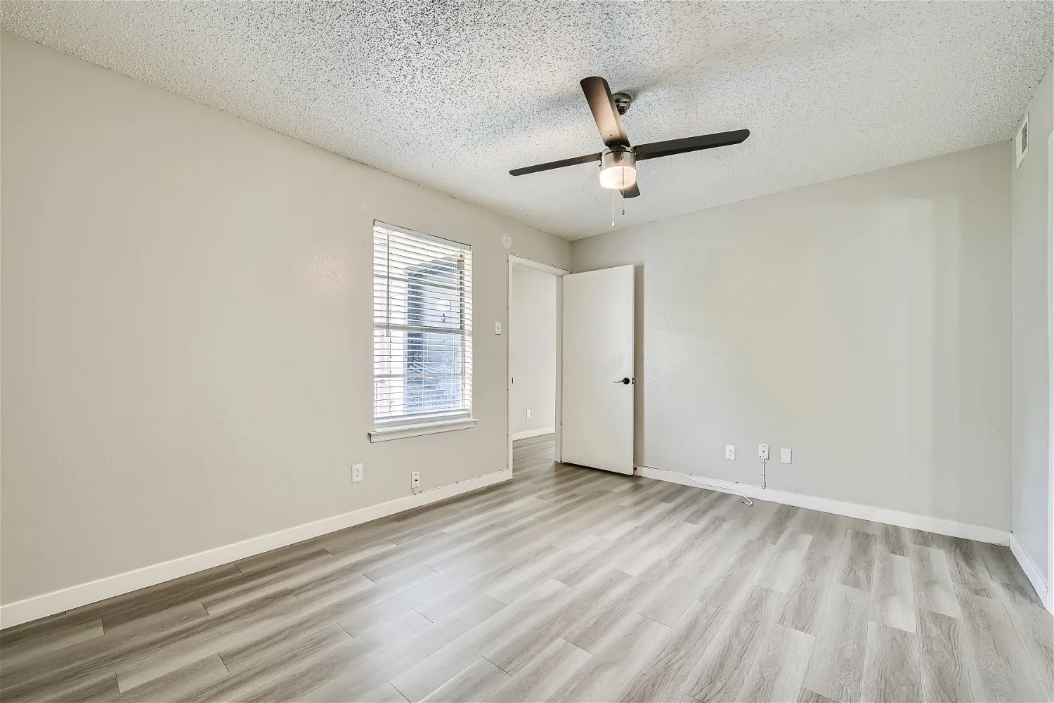 Primary bedroom with ceiling fan and closet access