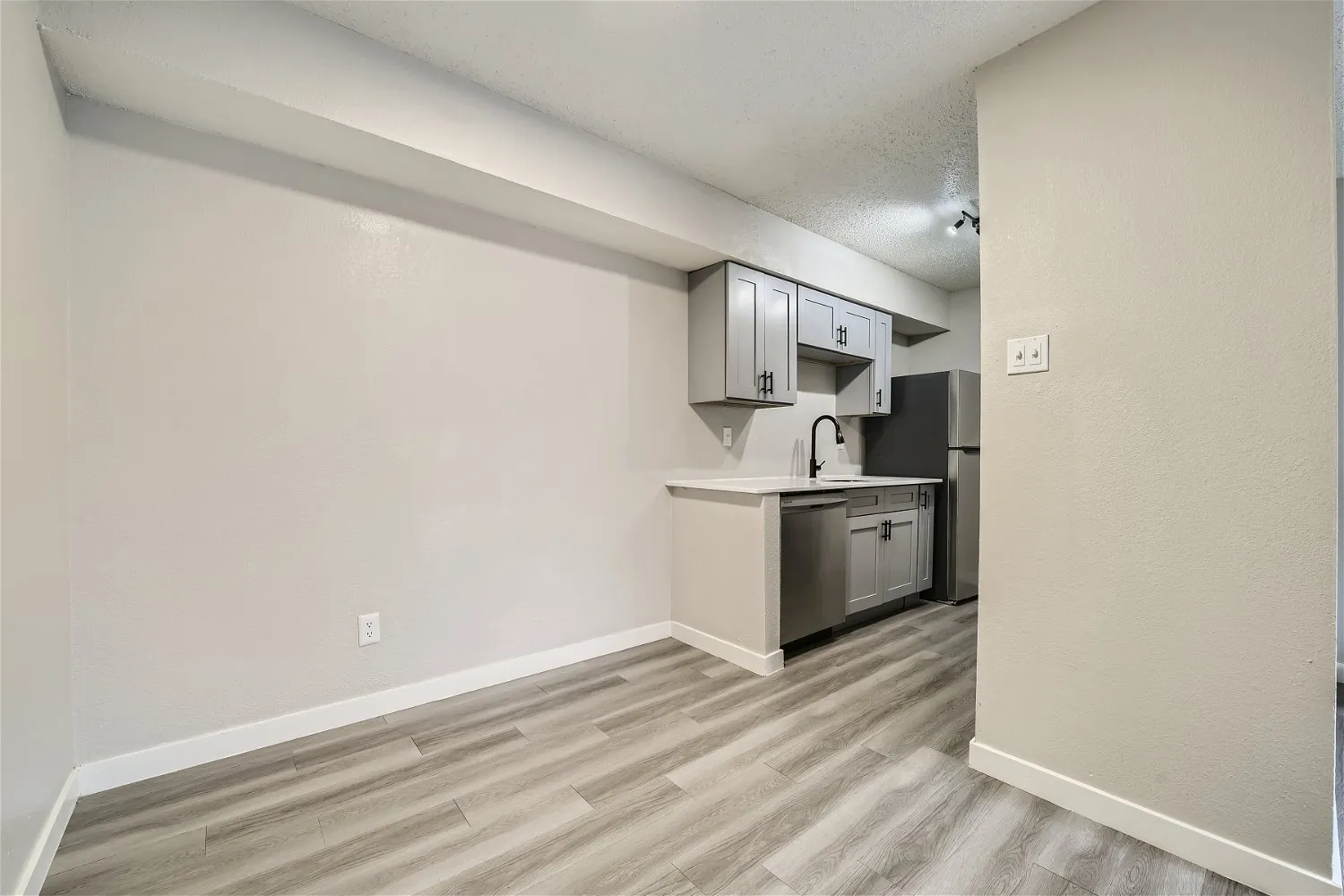 Dining area with open kitchen view and stainless refrigerator