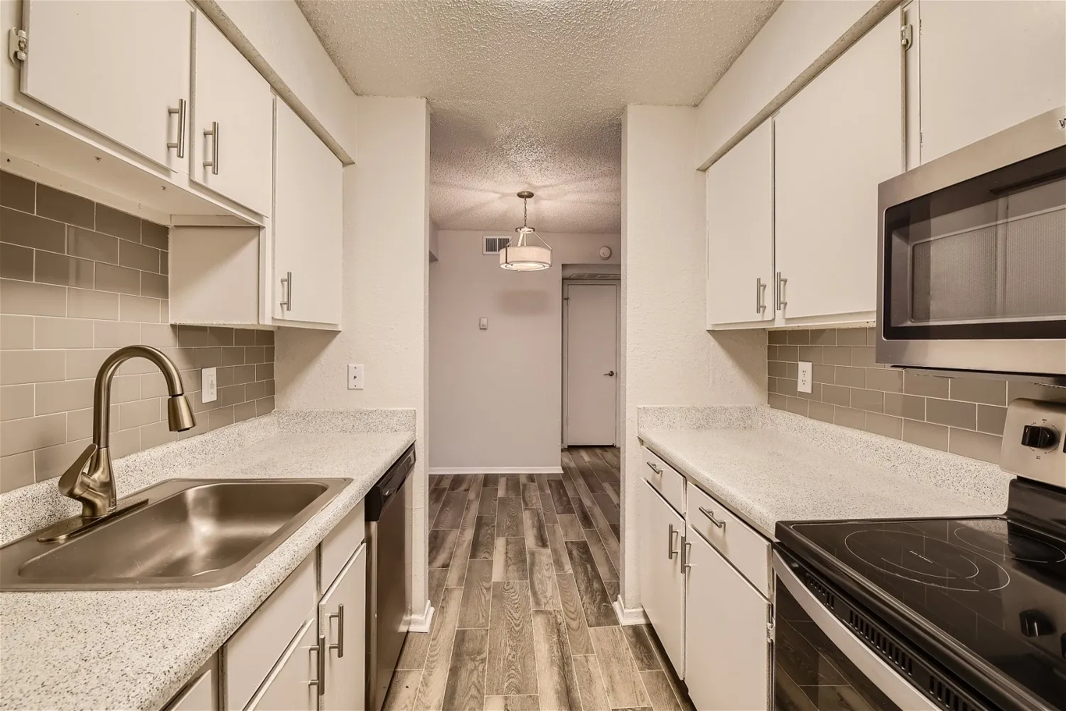 Kitchen with stainless appliances and speckled countertops
