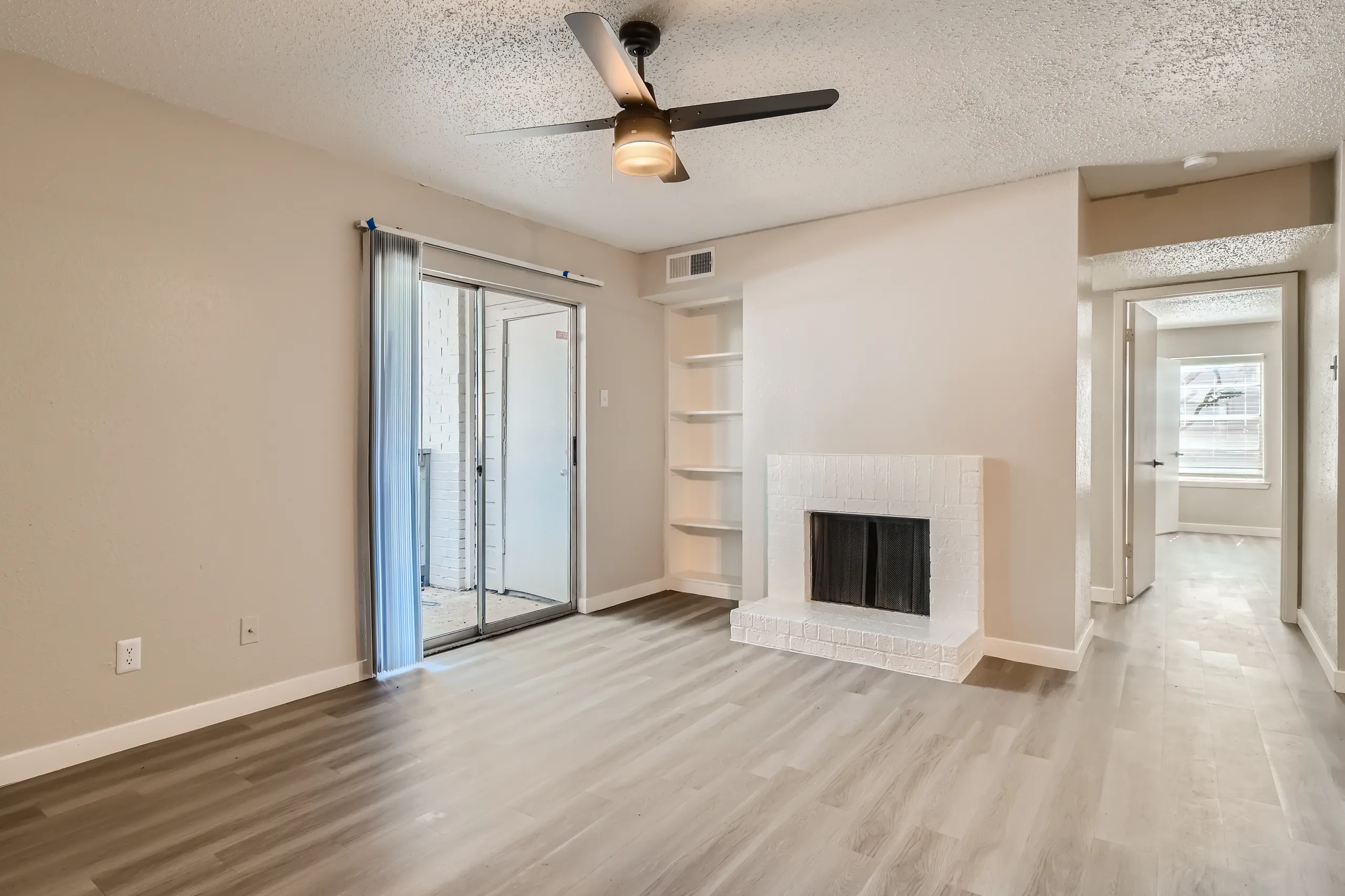 B2 Platinum floor plan living room with painted brick fireplace and built-in shelving