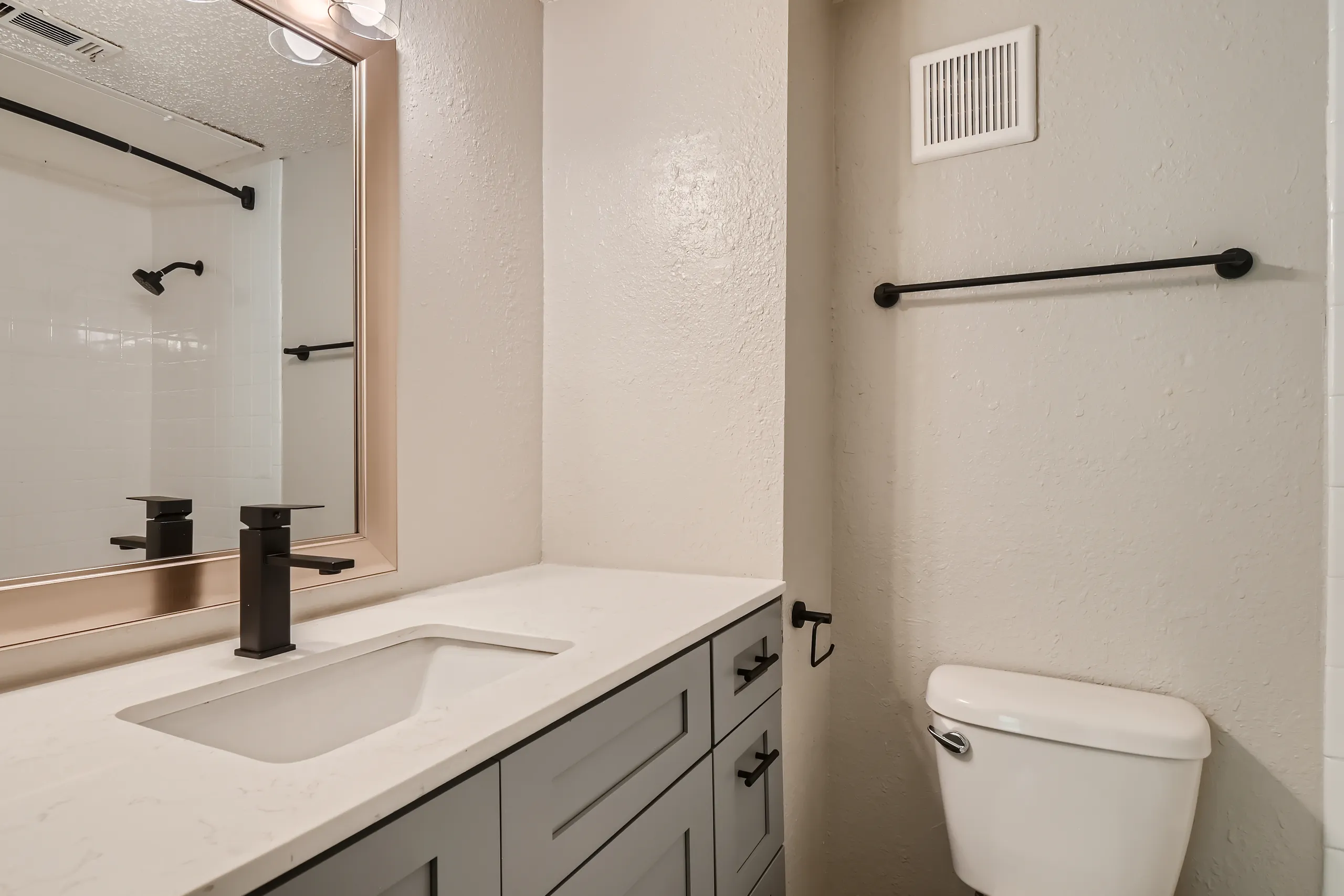 Second bathroom with tub shower combo and gray vanity