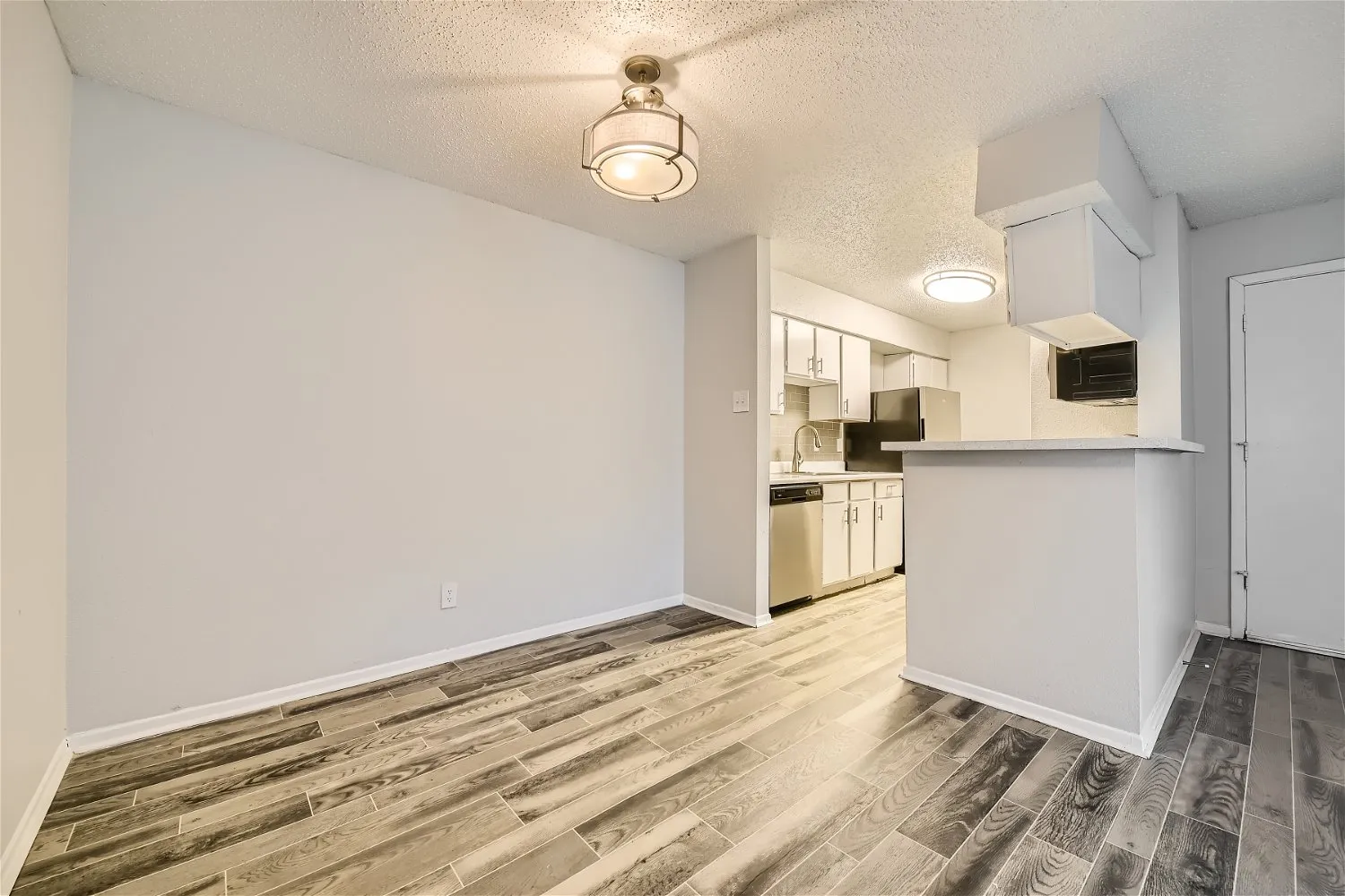 Dining area with pendant light and open kitchen view