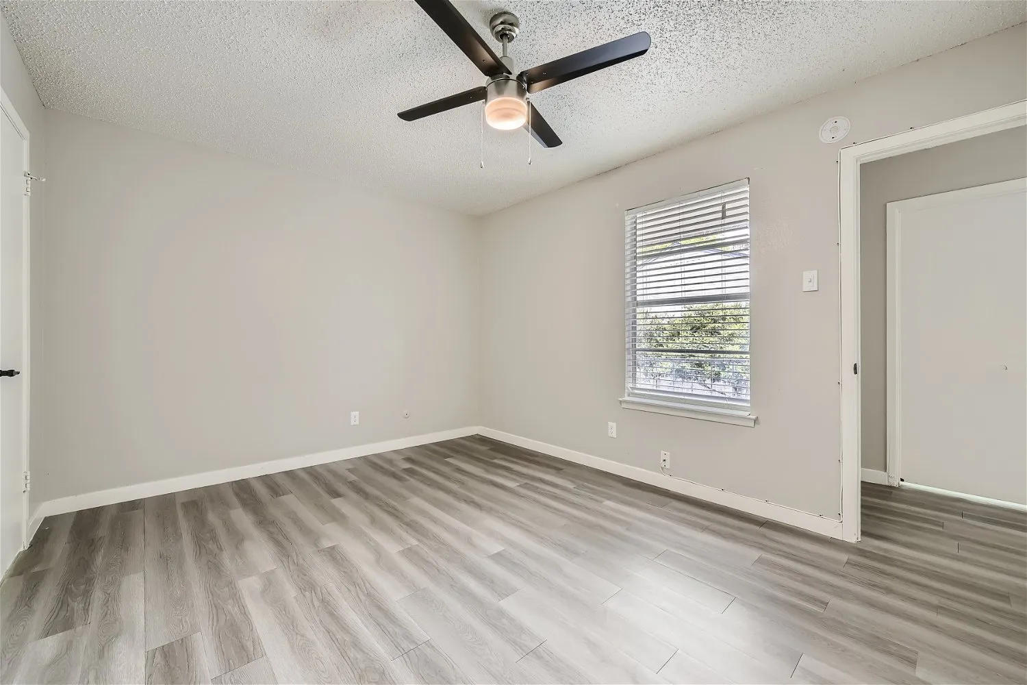 Primary bedroom with ceiling fan and large window