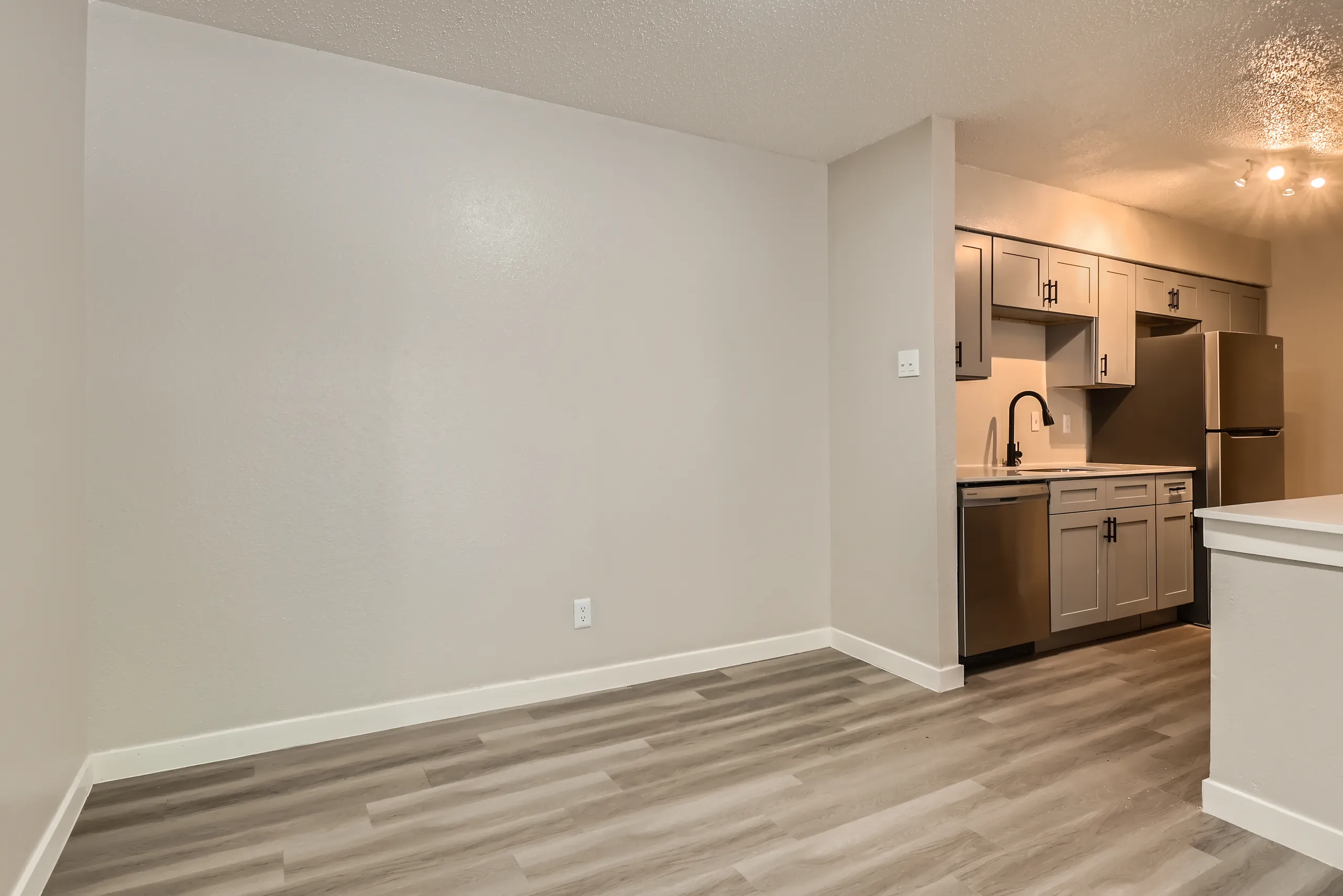 Dining area with open kitchen view and stainless refrigerator