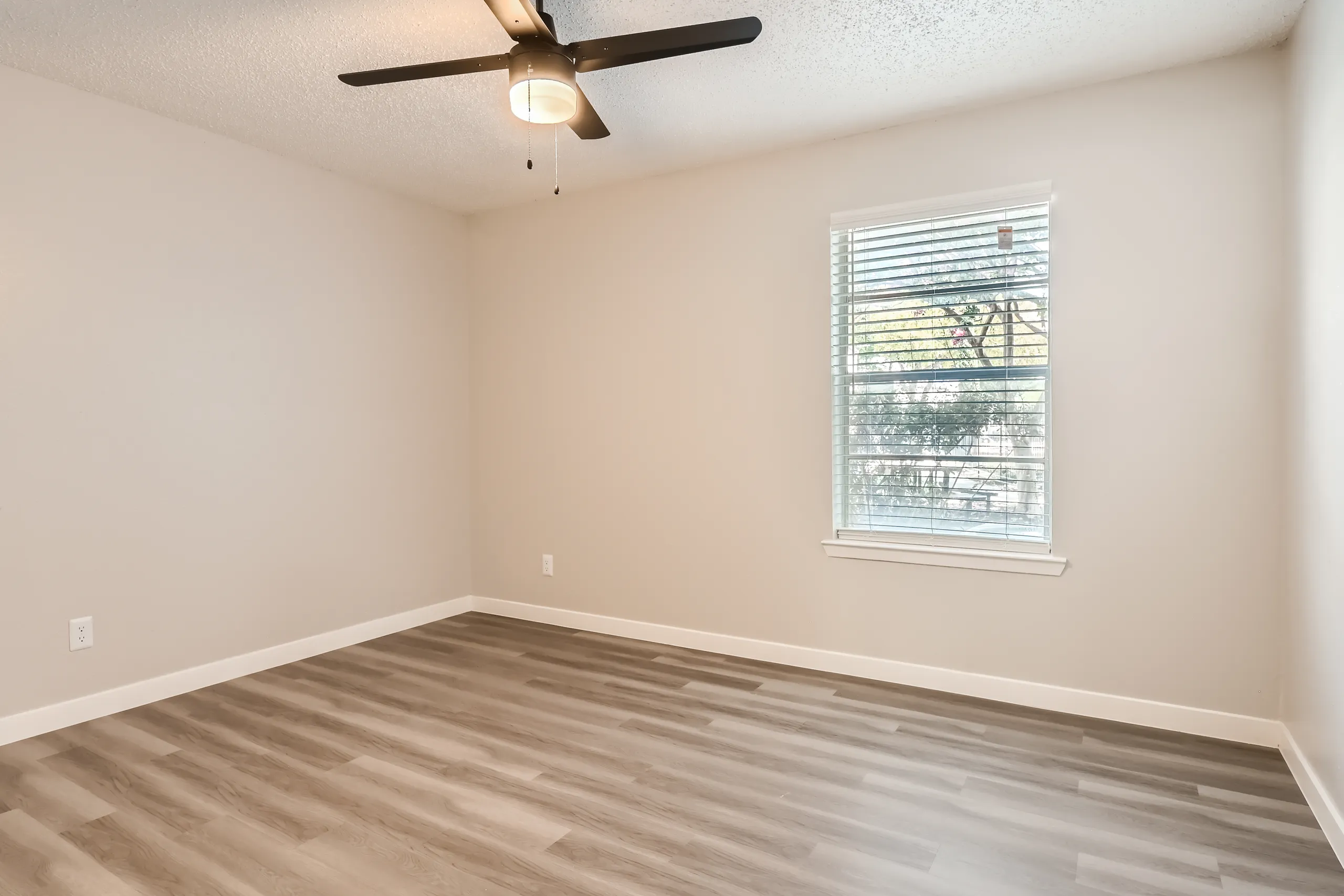 Primary bedroom with ceiling fan and large window