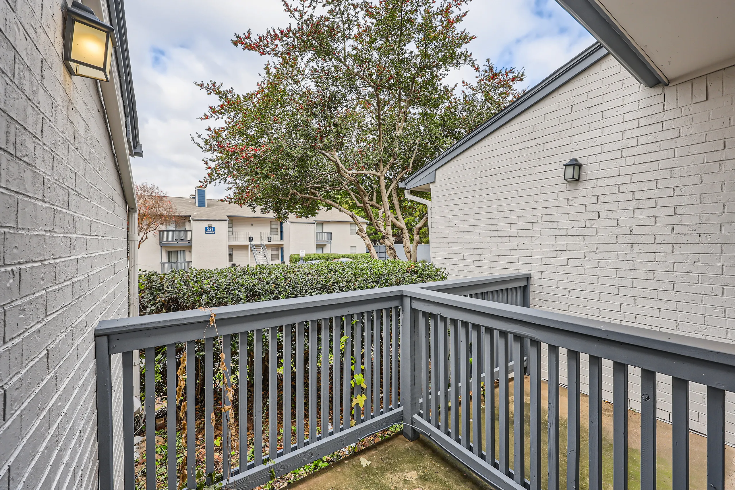 Private patio with hedges and courtyard view