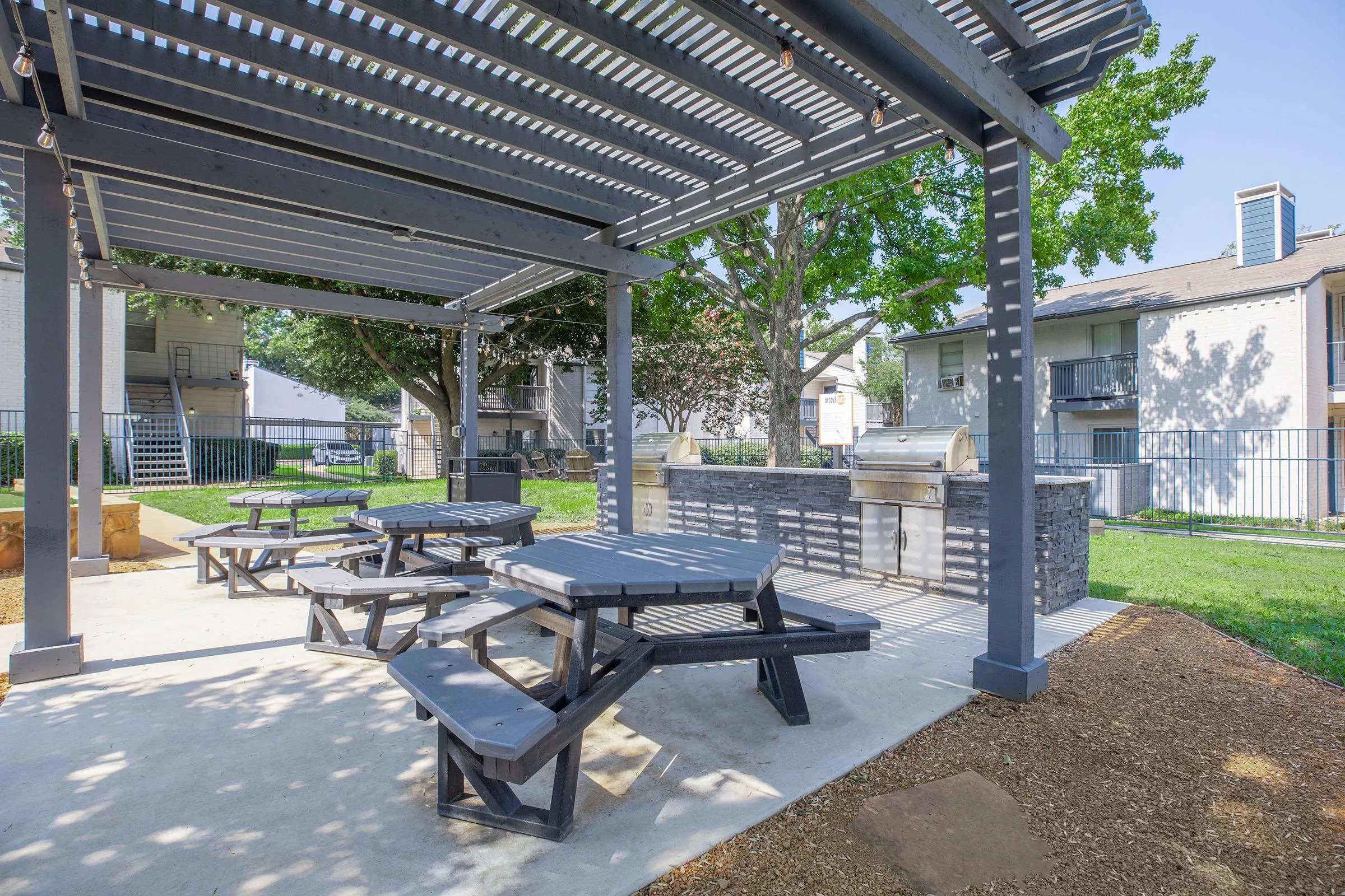Pergola-covered patio, picnic tables, built-in grills