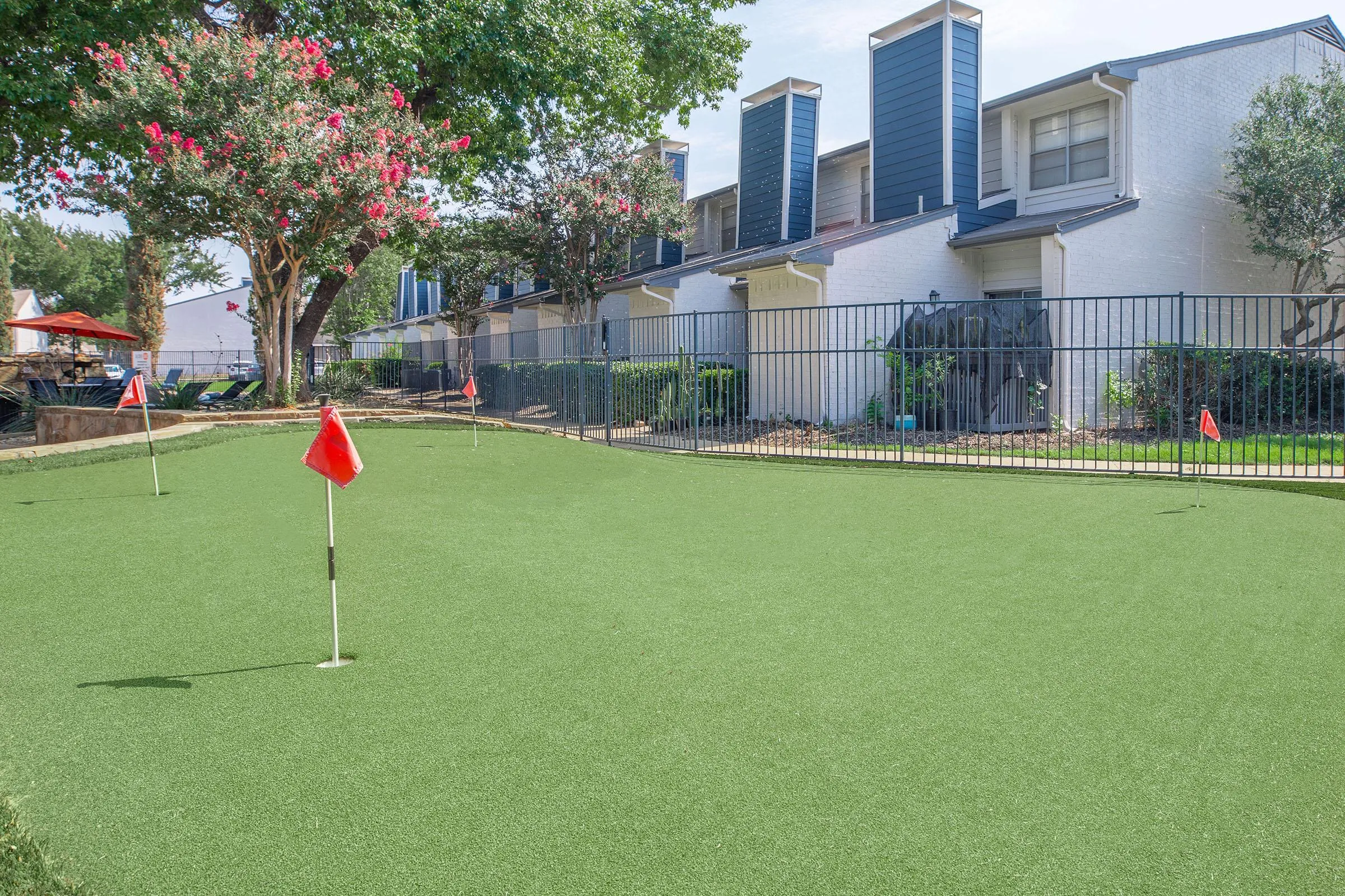 Artificial turf putting green, flagged holes, fenced border