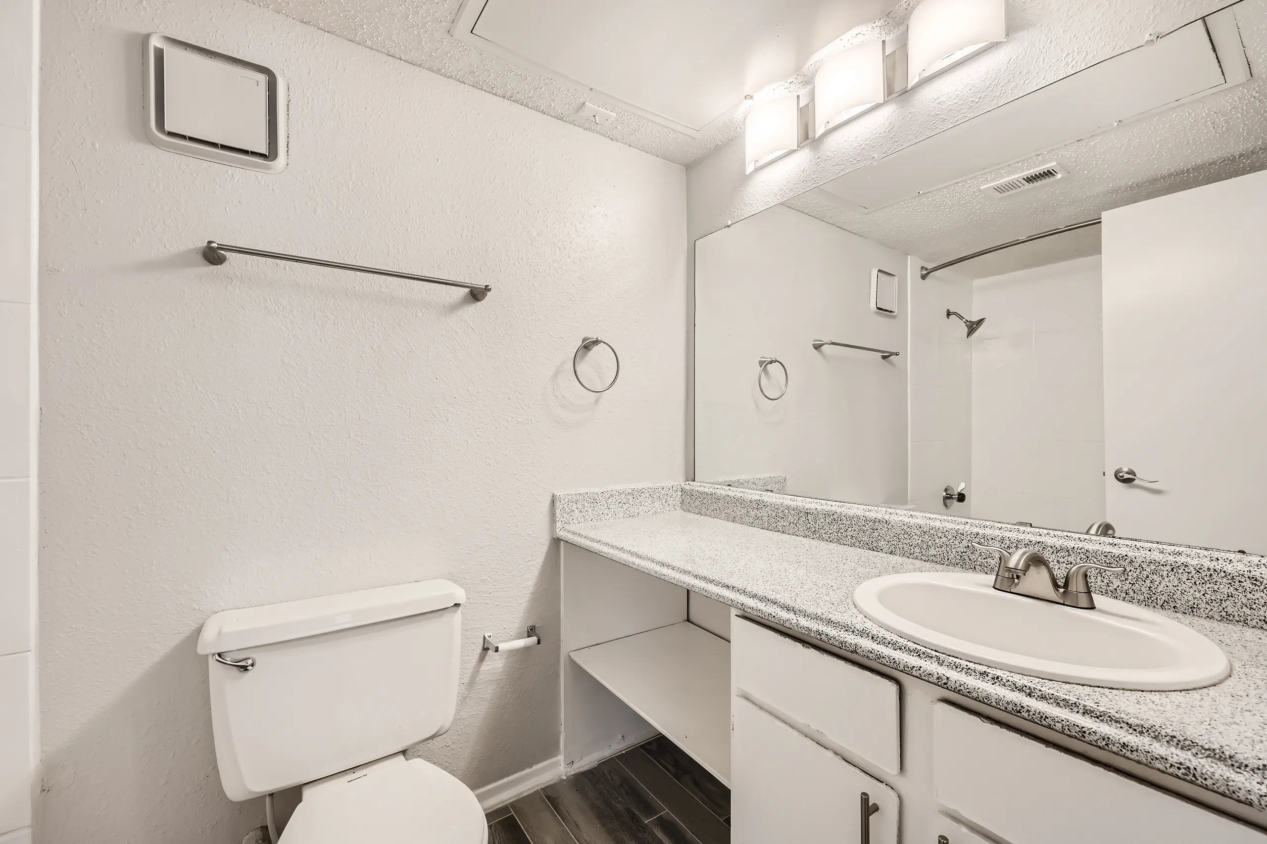 Primary bathroom with granite-style vanity and tub shower combo
