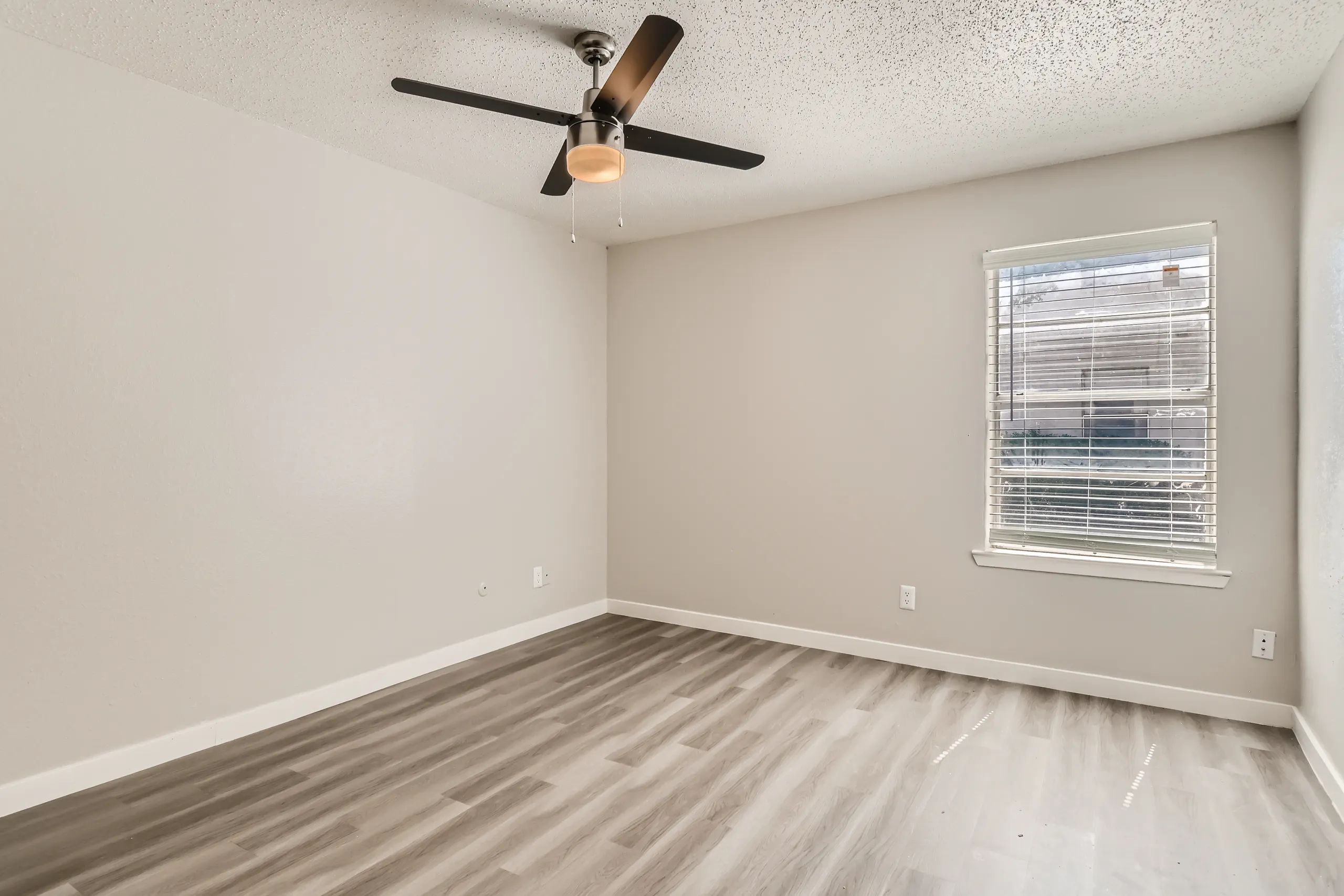 Second bedroom with ceiling fan and large window