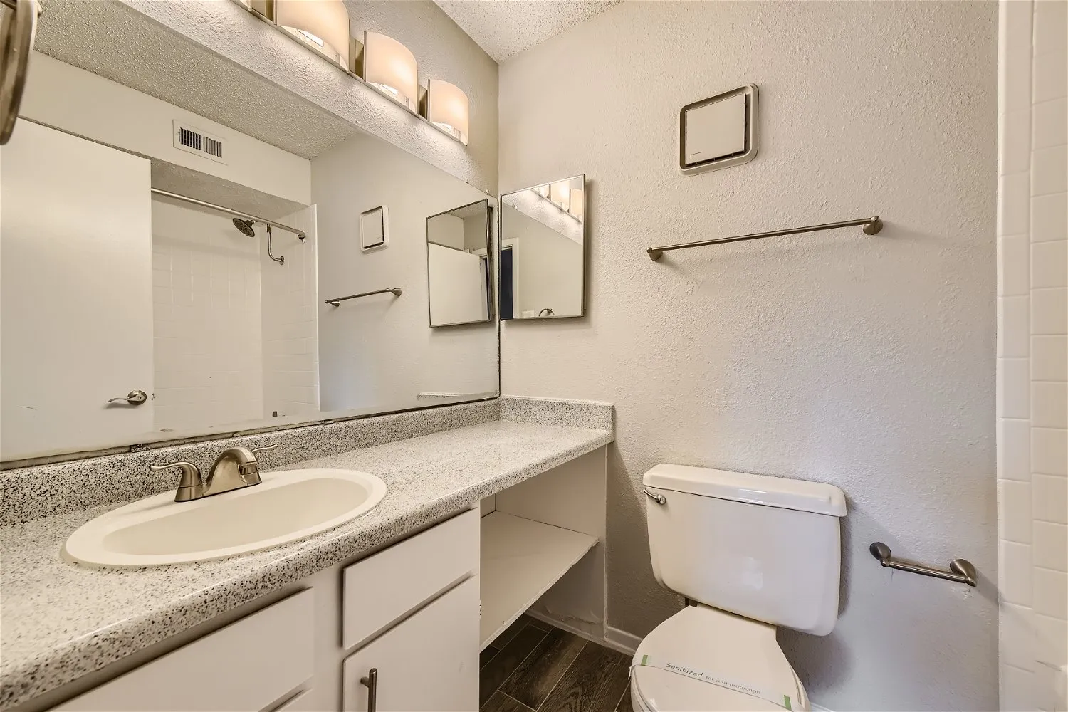 Primary bathroom with dual mirrors and speckled vanity