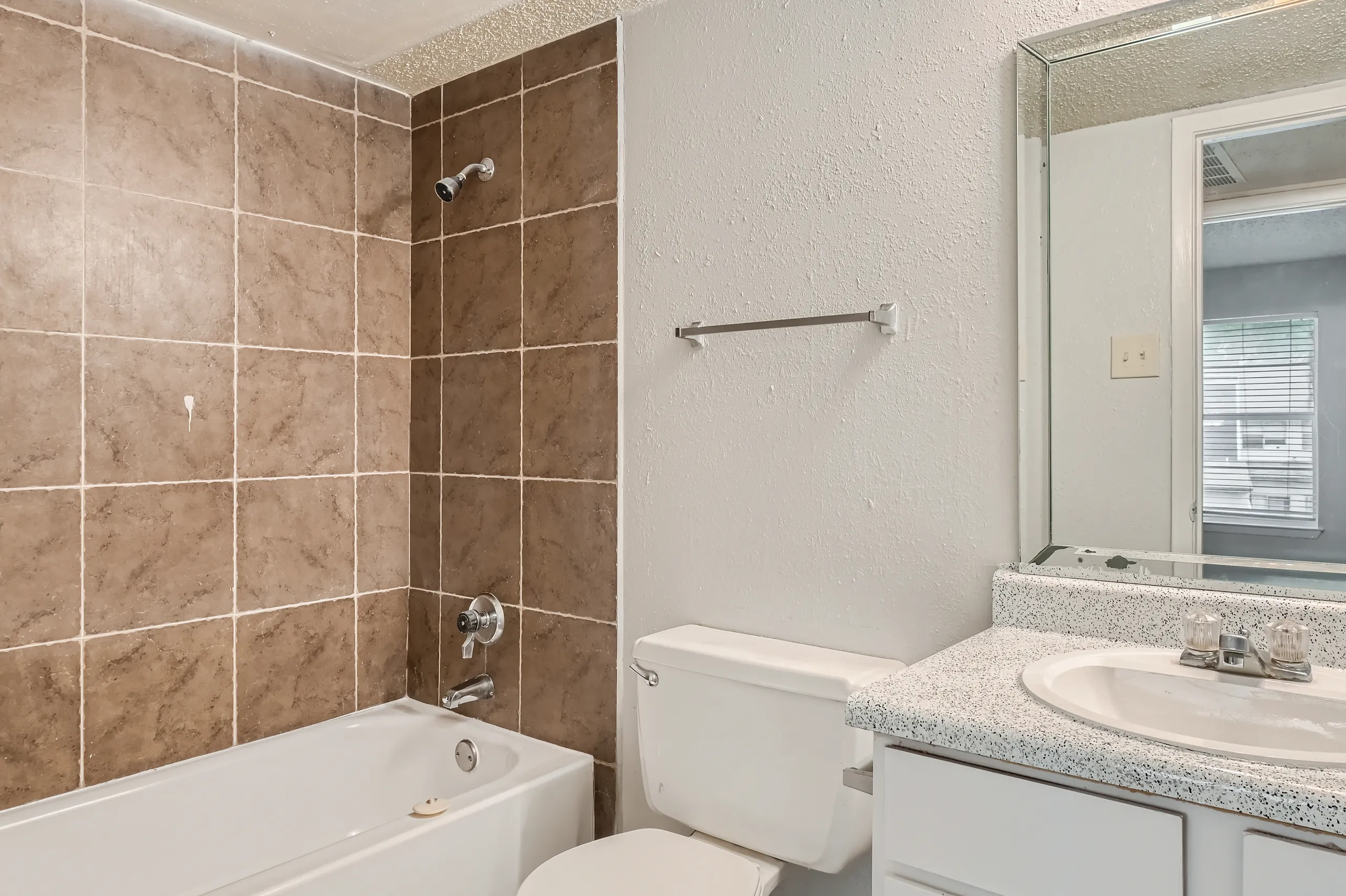 Primary bathroom with tiled tub surround and vanity mirror