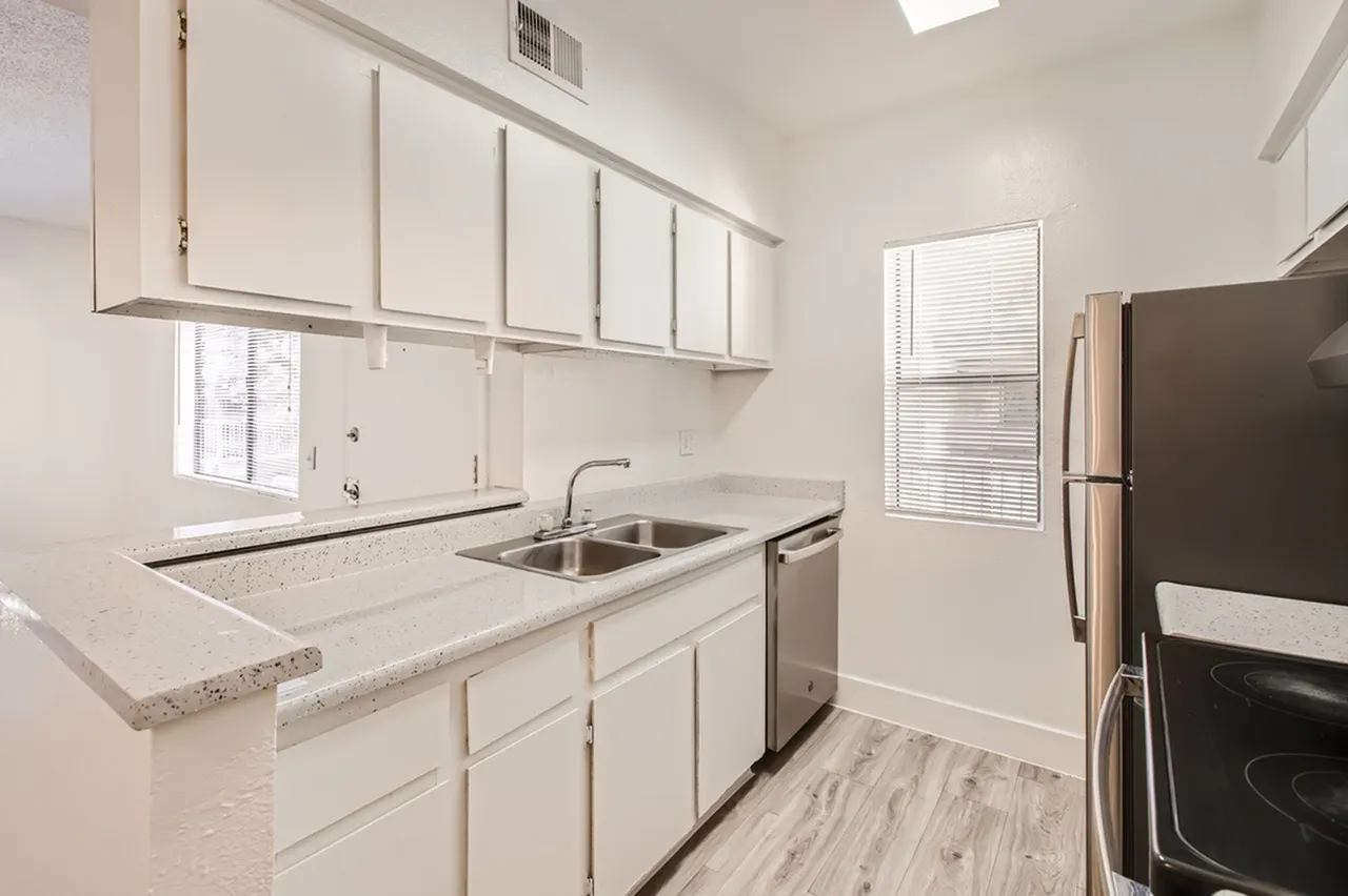 Kitchen, white shaker cabinetry, quartz countertops, stainless steel sink, wood-style plank flooring