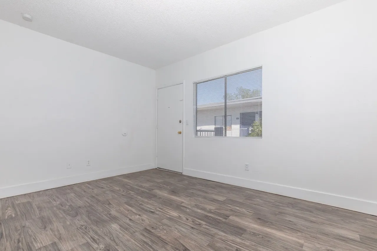 Bedroom, wood-style plank flooring, white walls, entry door, window