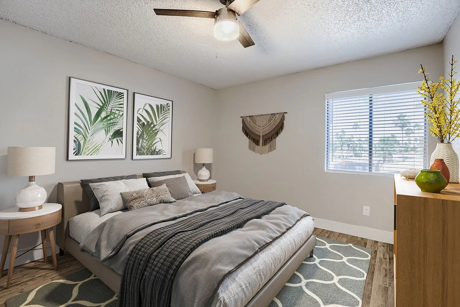 Primary bedroom, wood-style plank flooring, upholstered bed frame, ceiling fan with light