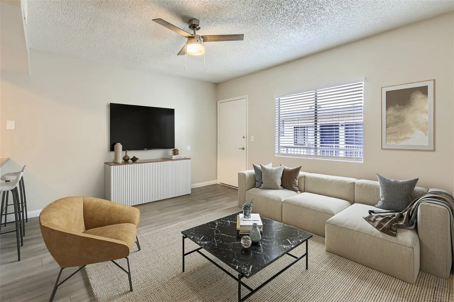 Living room, wood-style plank flooring, ceiling fan, flat screen TV, tan sectional sofa