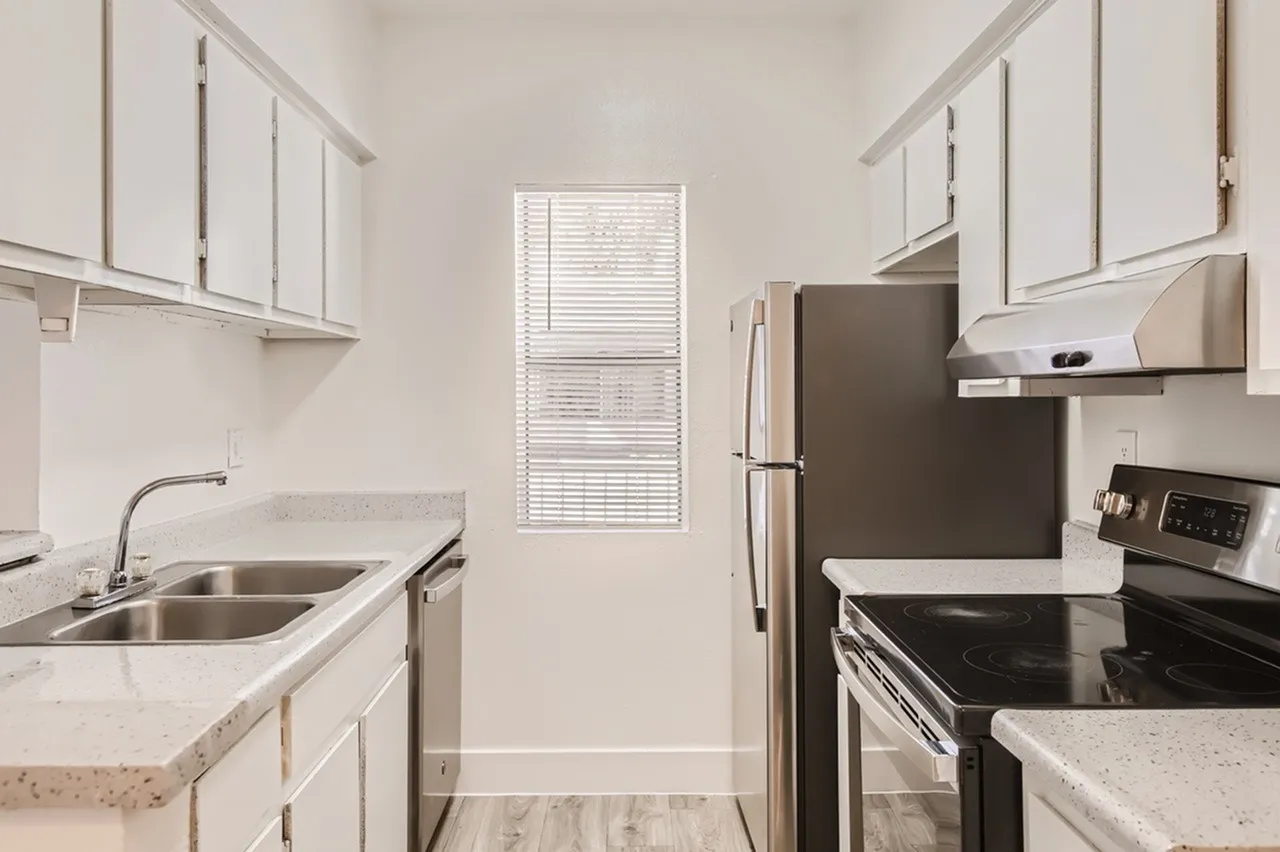 Kitchen, white shaker cabinetry, quartz countertops, stainless appliances, wood-style plank flooring