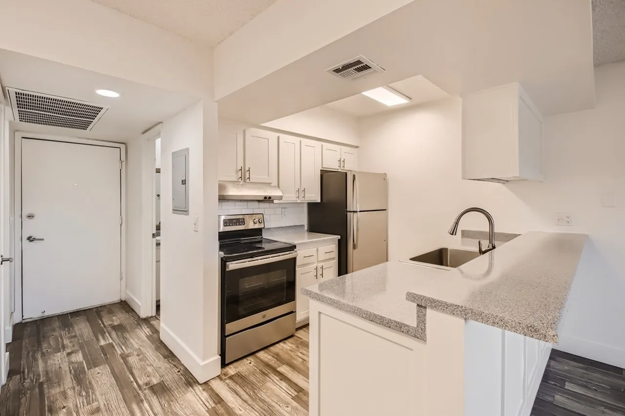 Kitchen, white shaker cabinetry, quartz countertops, stainless appliances, wood-style plank flooring