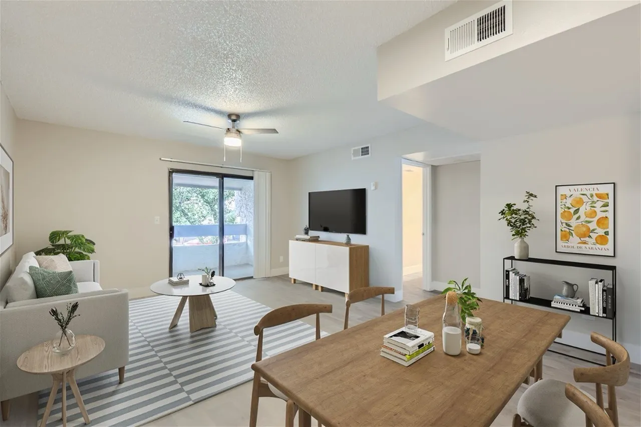 Living and dining space, wood-style plank flooring, ceiling fan, wall-mounted TV, dining table with chairs