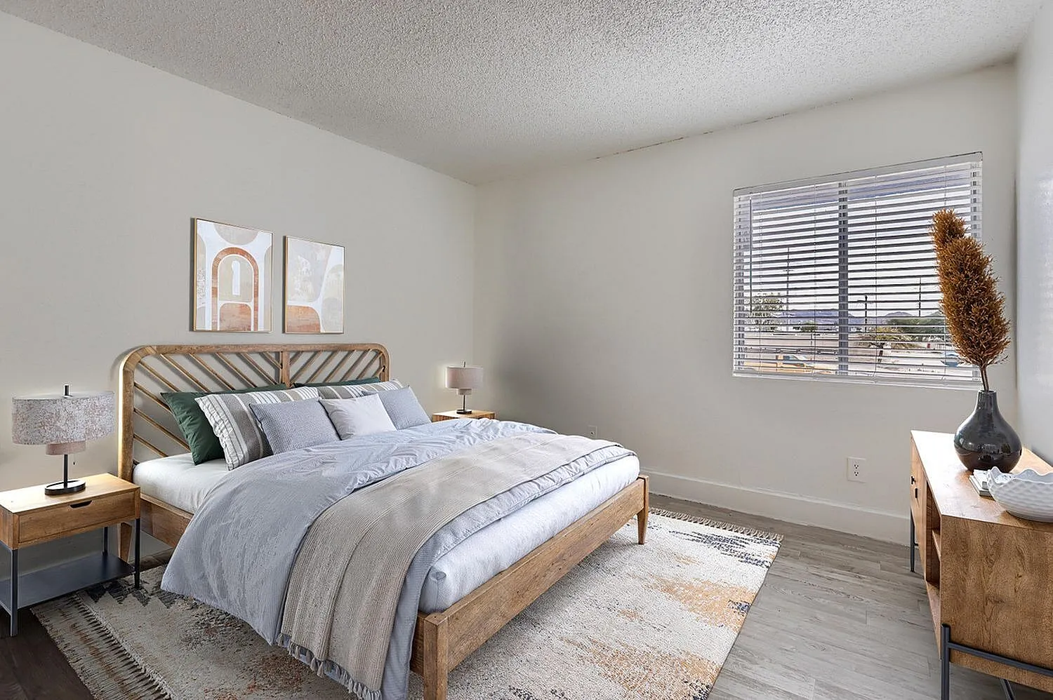 Primary bedroom, wood-style plank flooring, striped wood headboard, blue bedding, plantation shutters